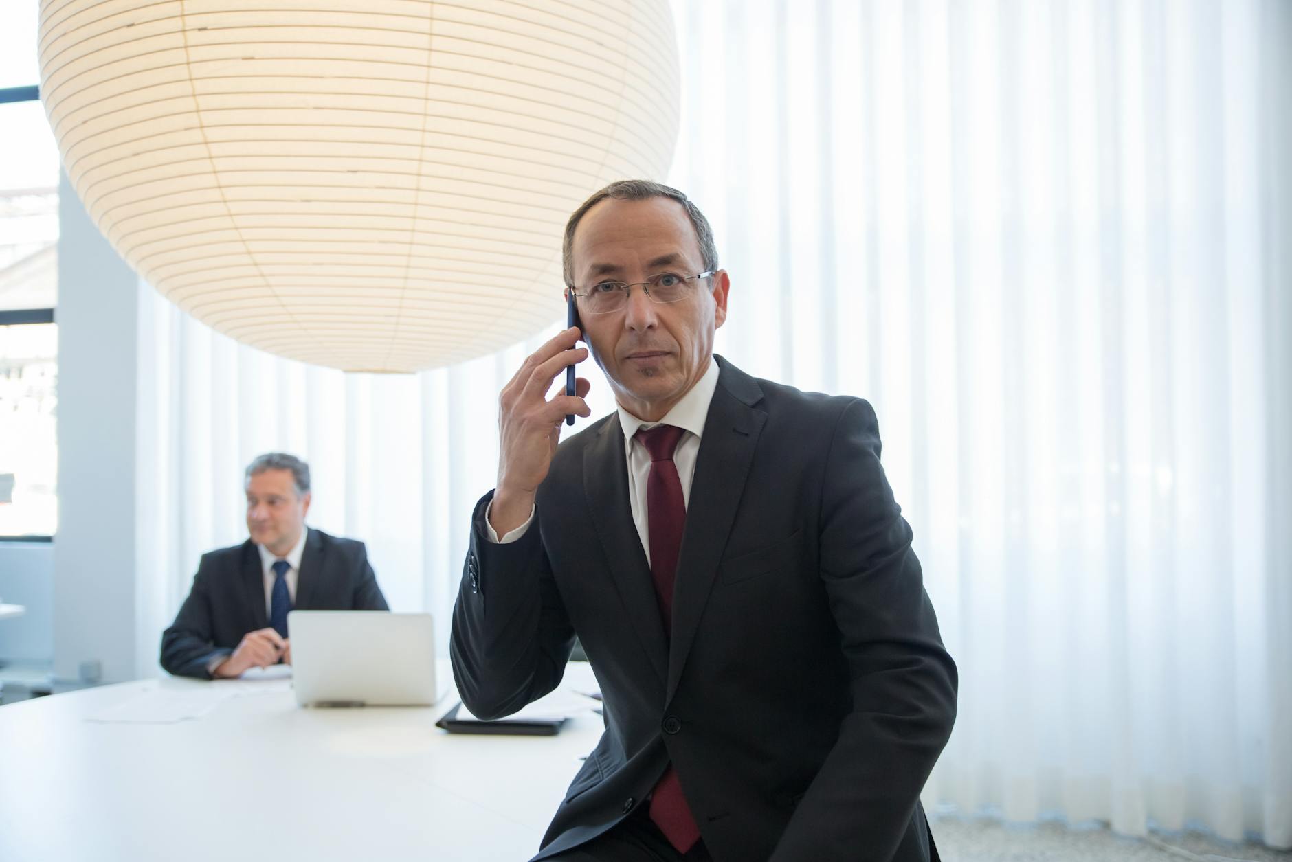 Business traveler on a call during a formal meeting