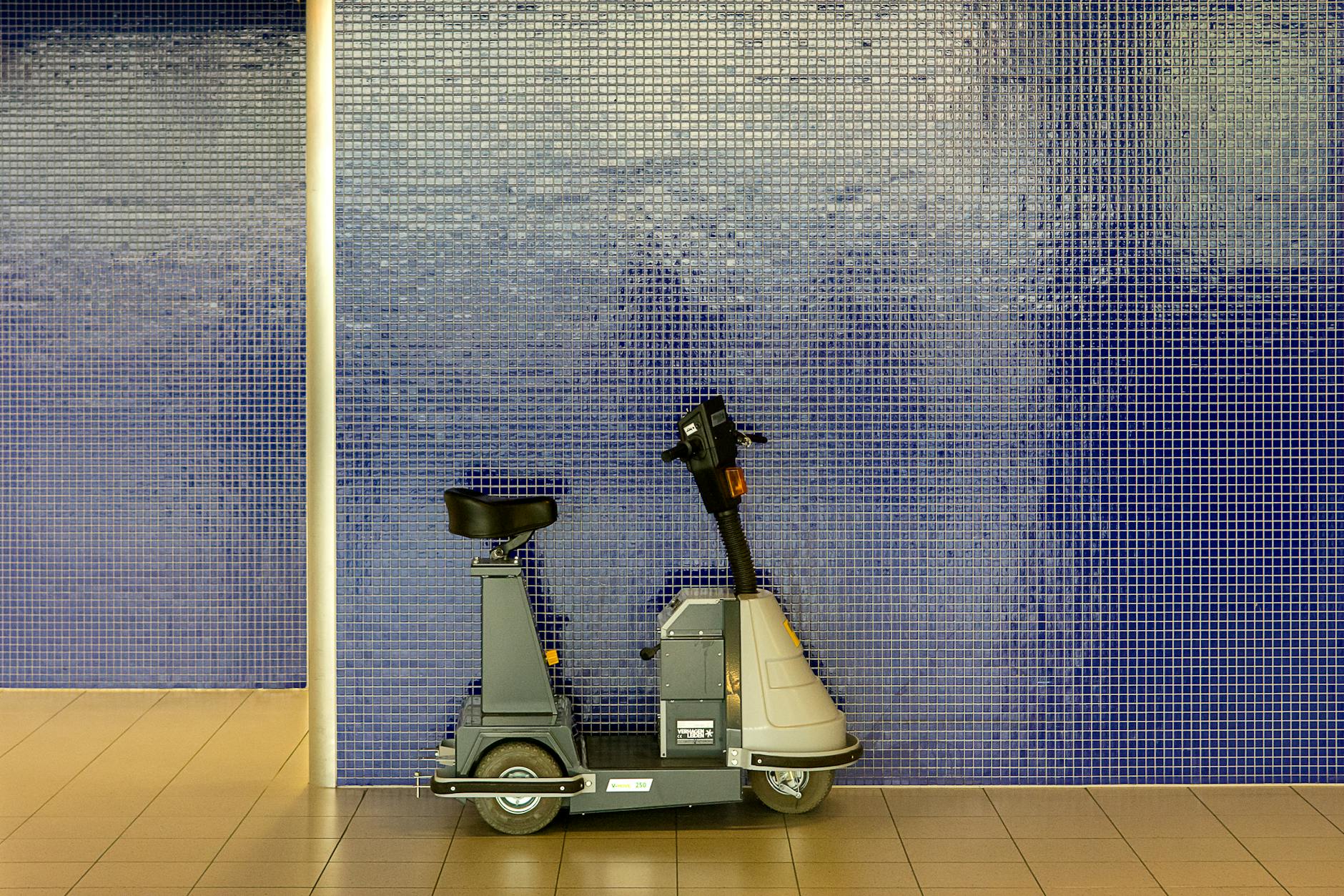 Mobility scooter parked by a tiled wall