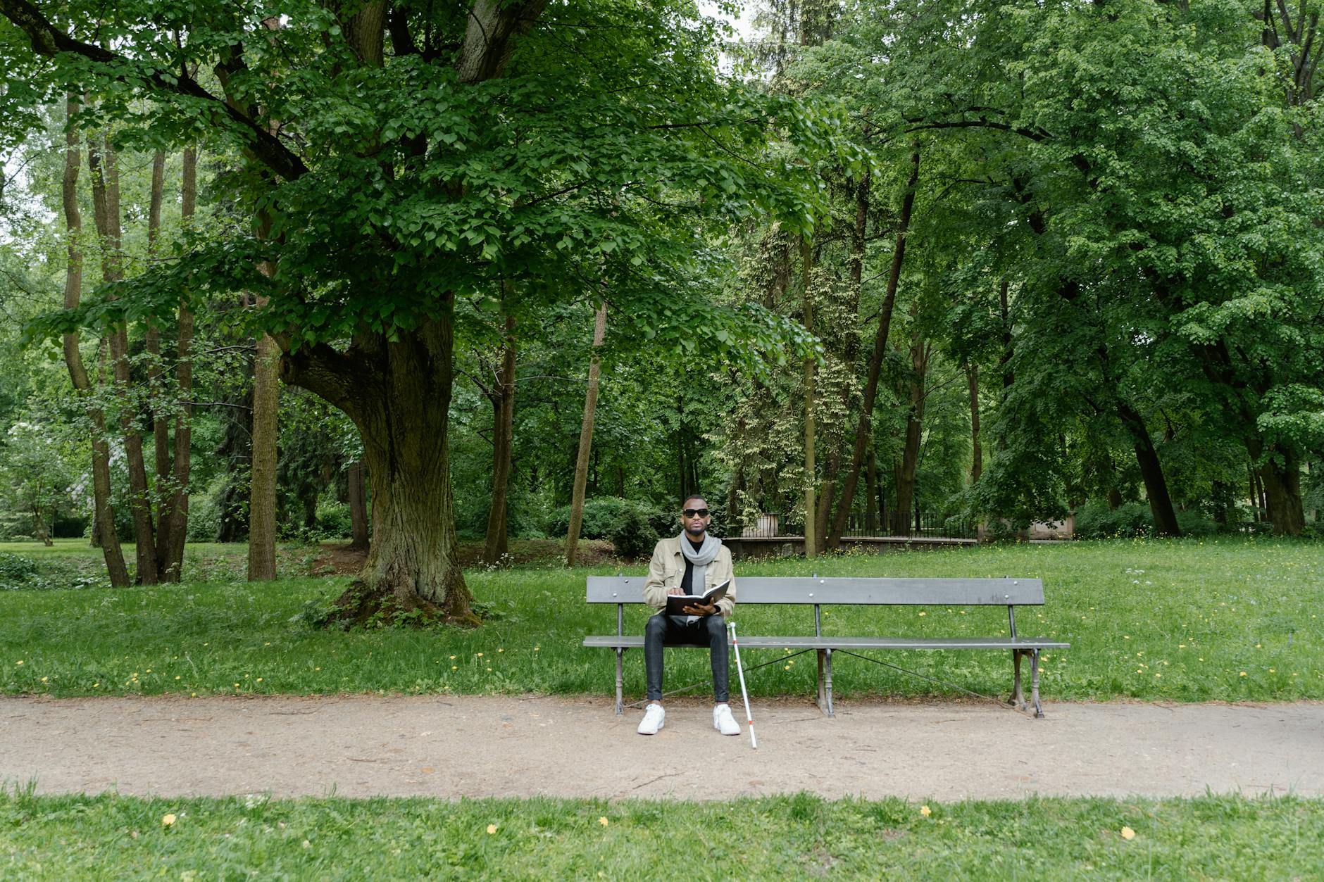 Man sitting on a park bench with a cane