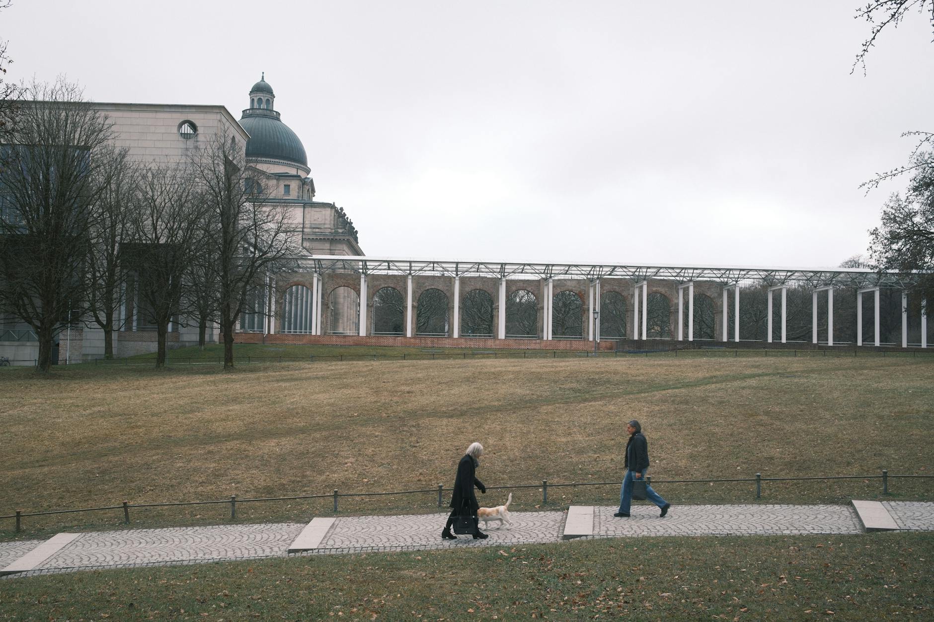 People walking in a Munich park near historic architecture