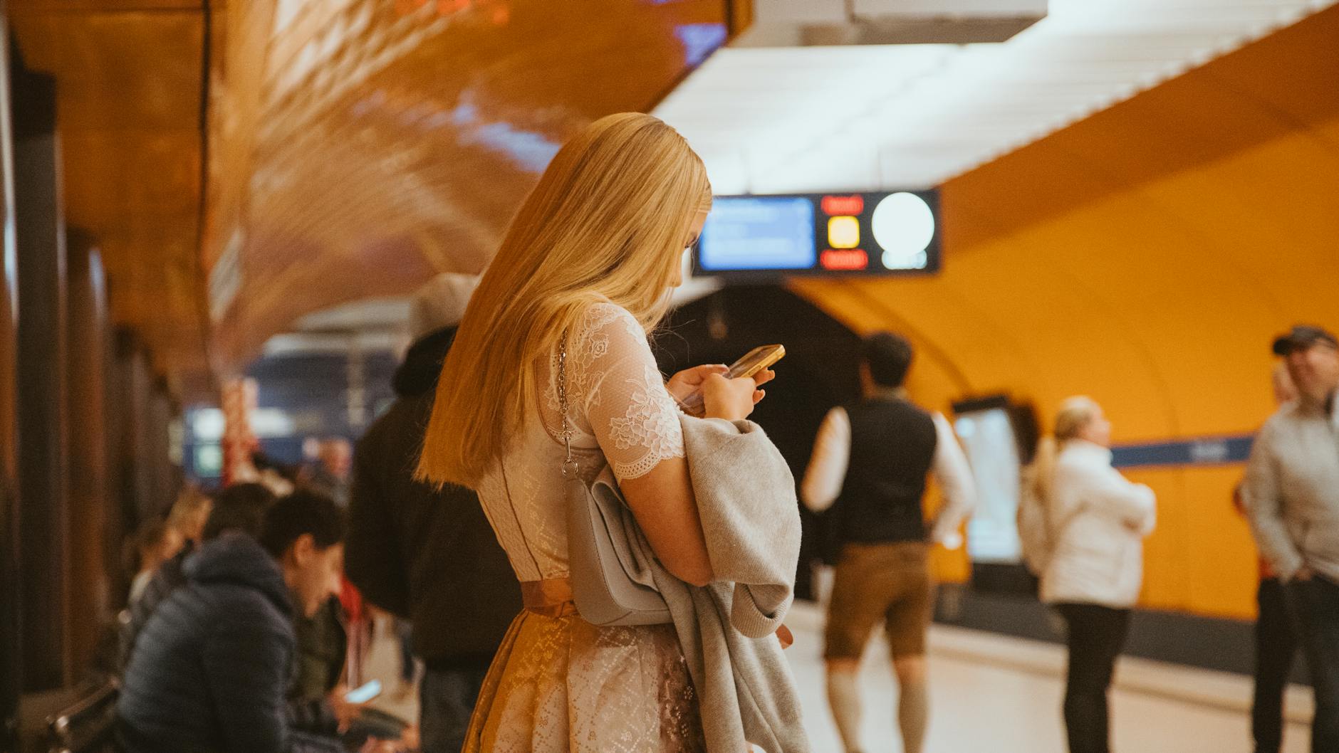 Woman using a smartphone in a Munich subway station