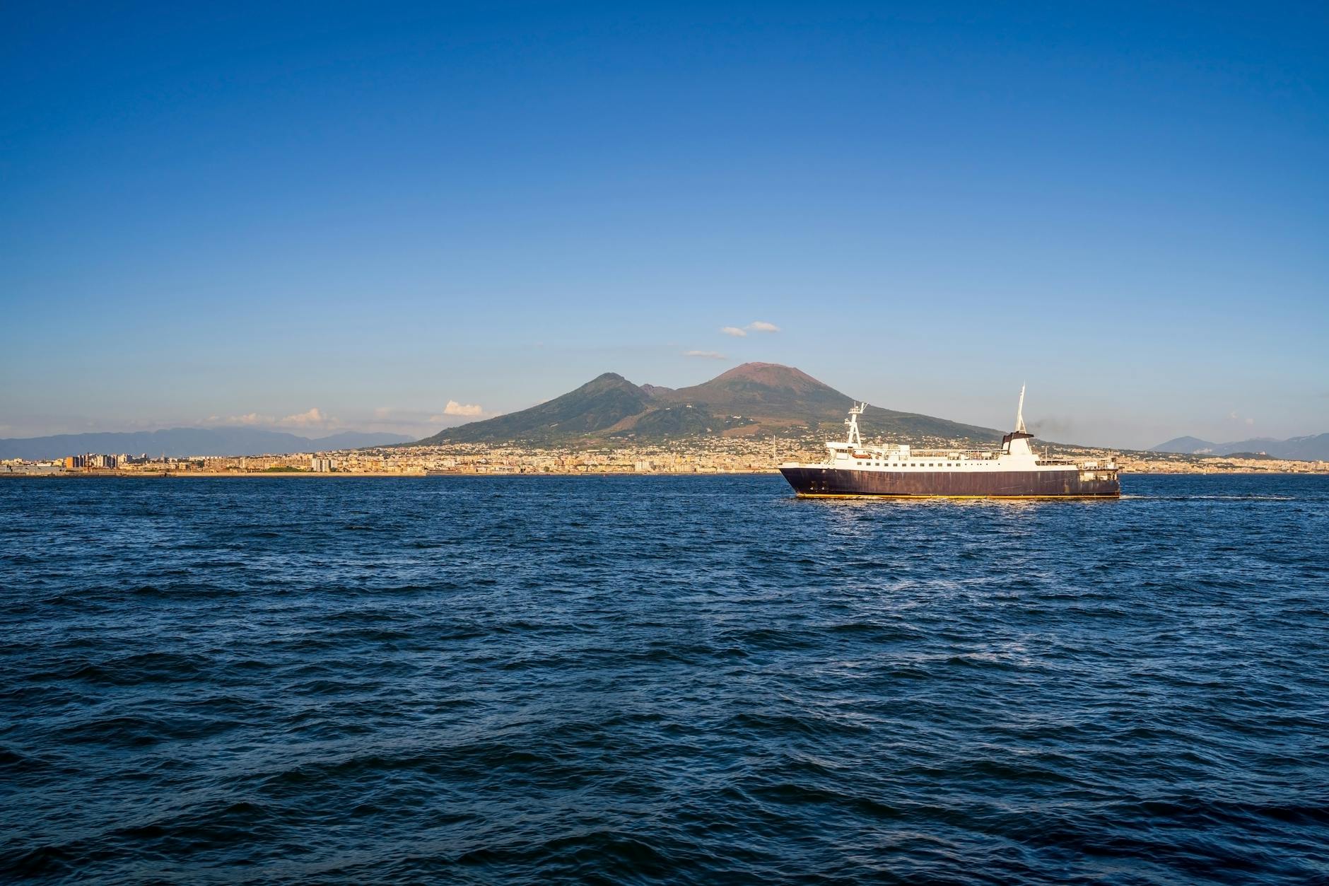 Ferry crossing the sea with Mount Vesuvius in the background