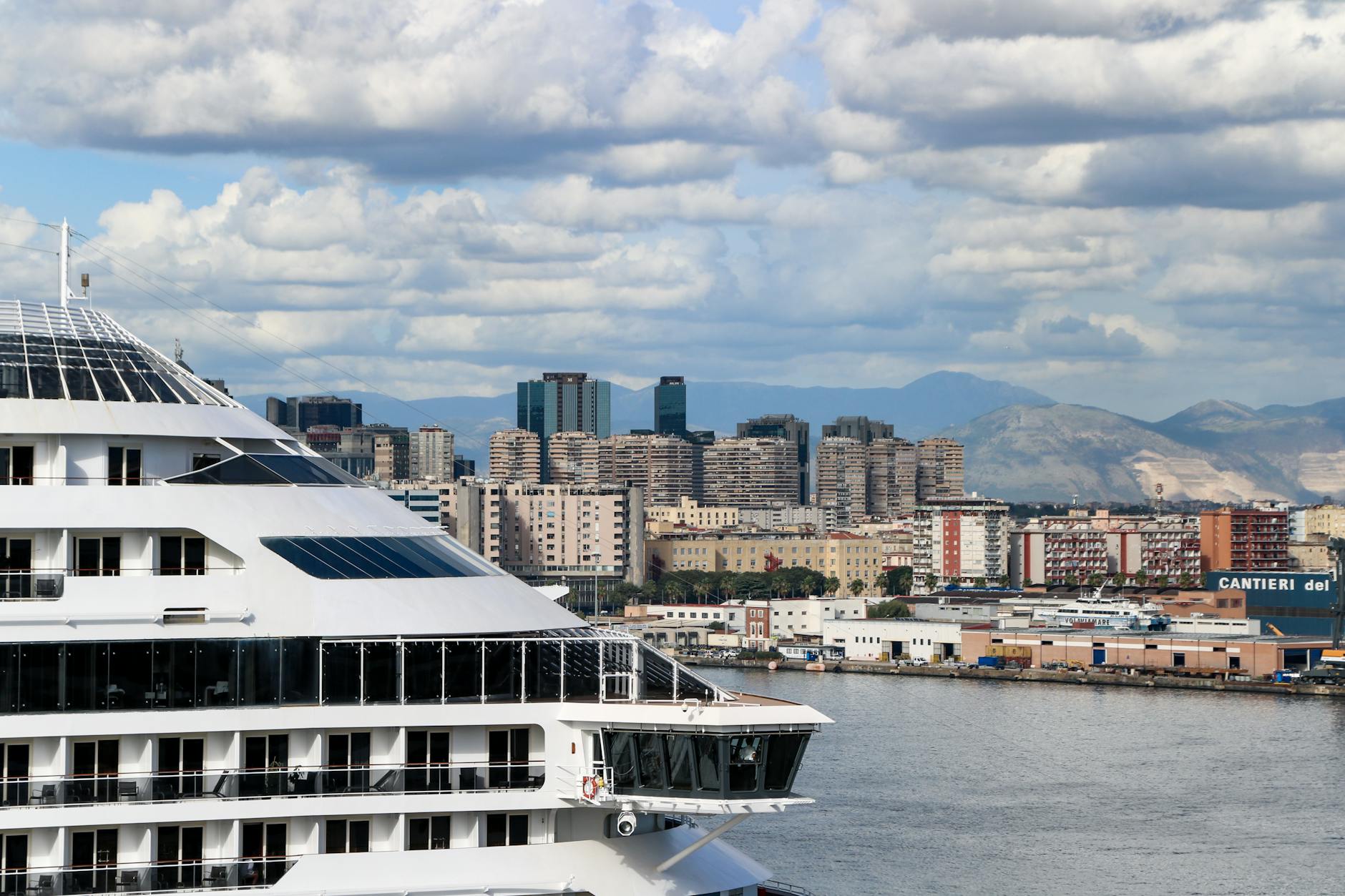 Cruise ship docked at Napoli port with the city behind it