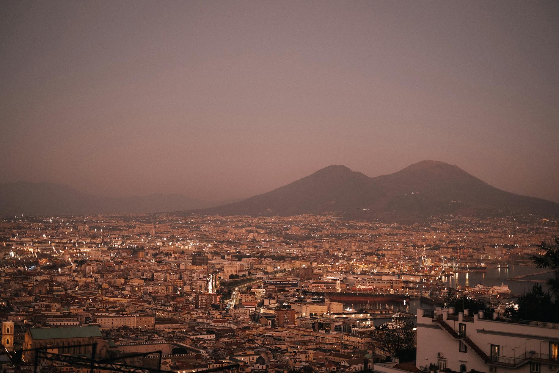 Naples cityscape at sunset with Mount Vesuvius in the distance
