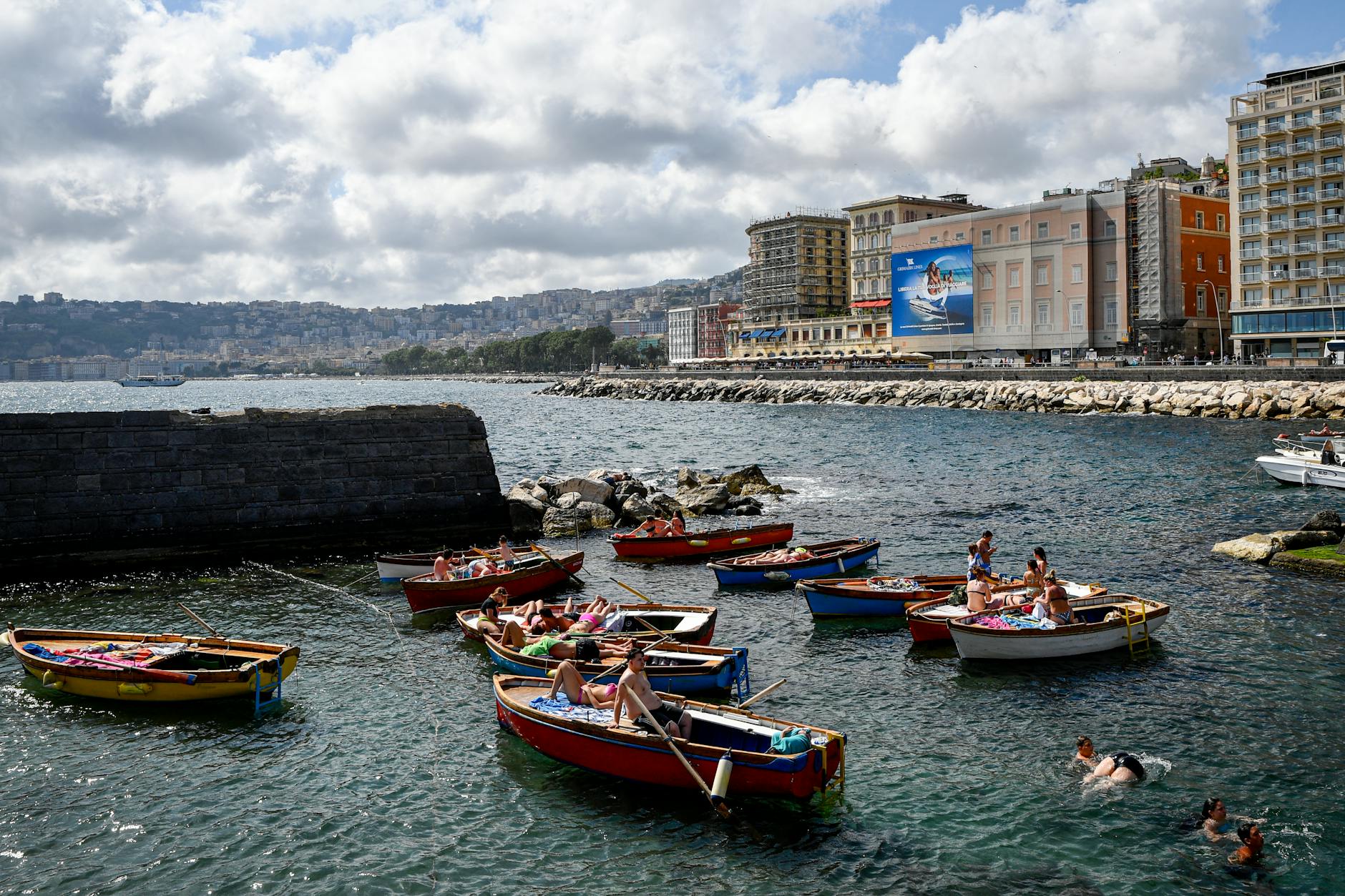 People in colorful boats along the Naples seafront