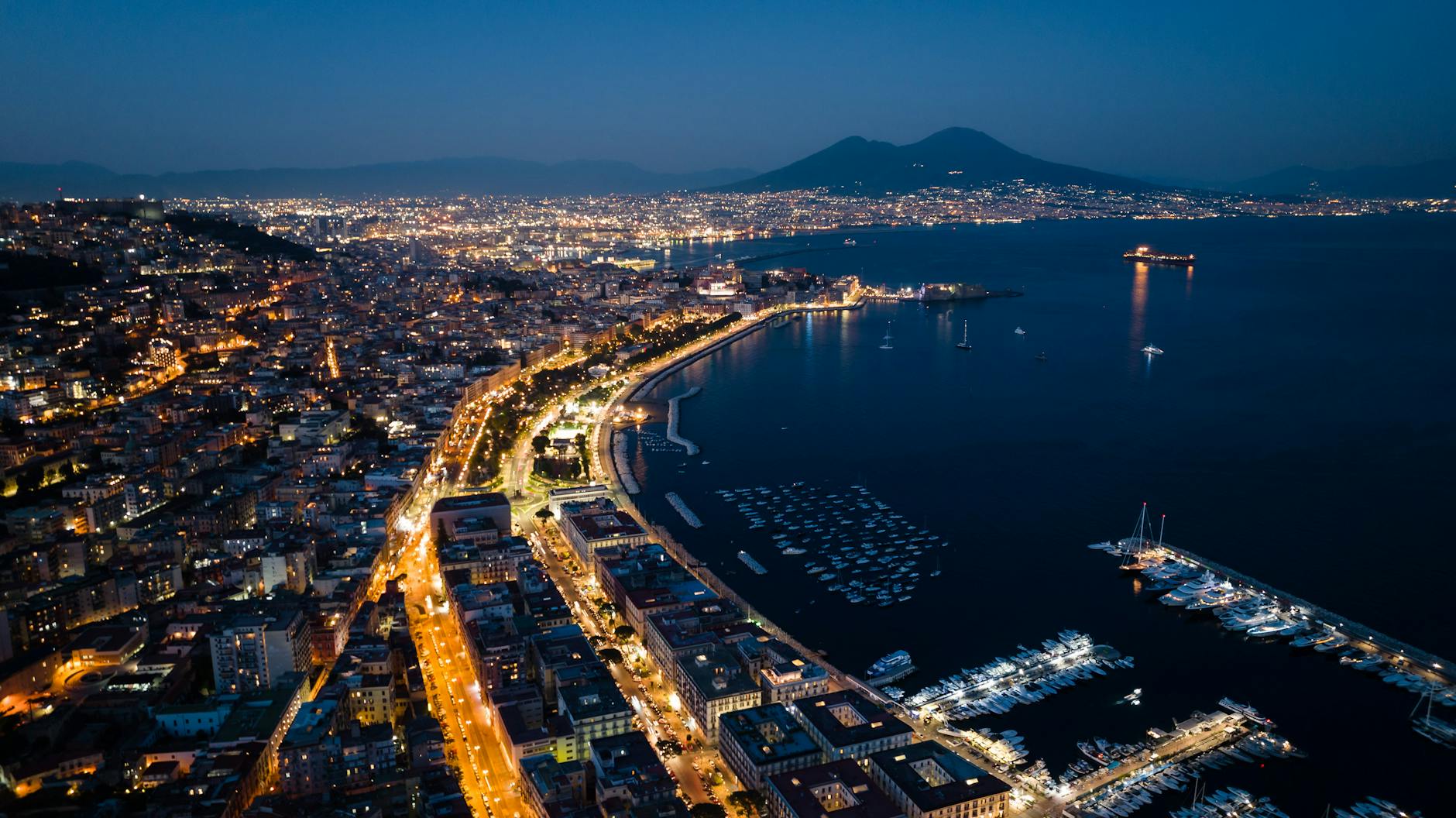 Naples harbor and cityscape illuminated at night