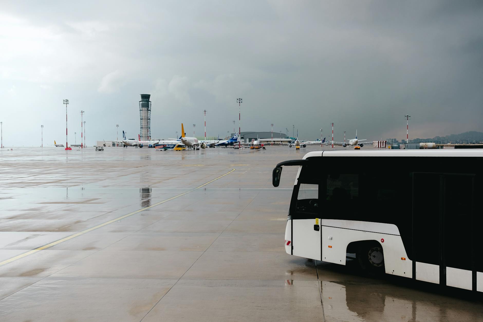 Airport tarmac with passenger bus and airplanes