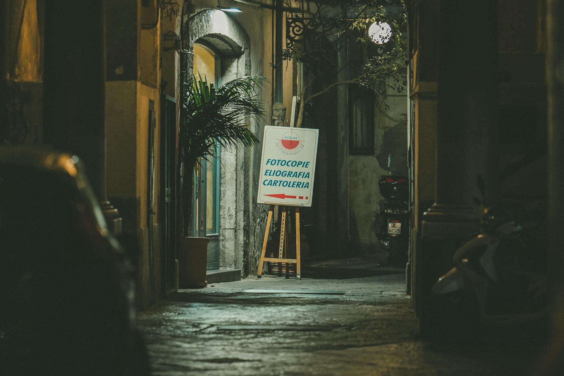Urban alleyway in Naples with warm lighting and signage
