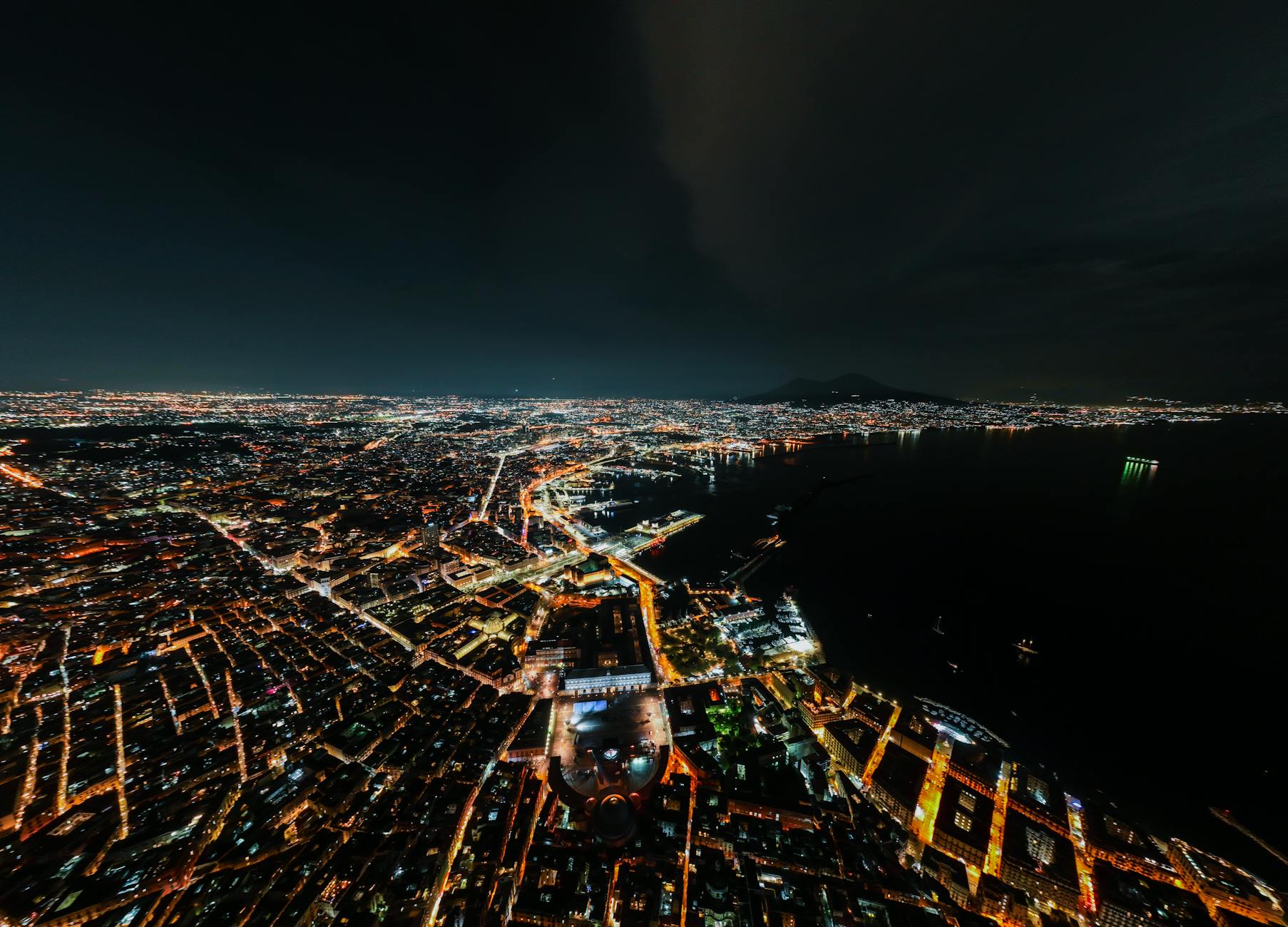 Aerial night view of Naples city lights and harbor