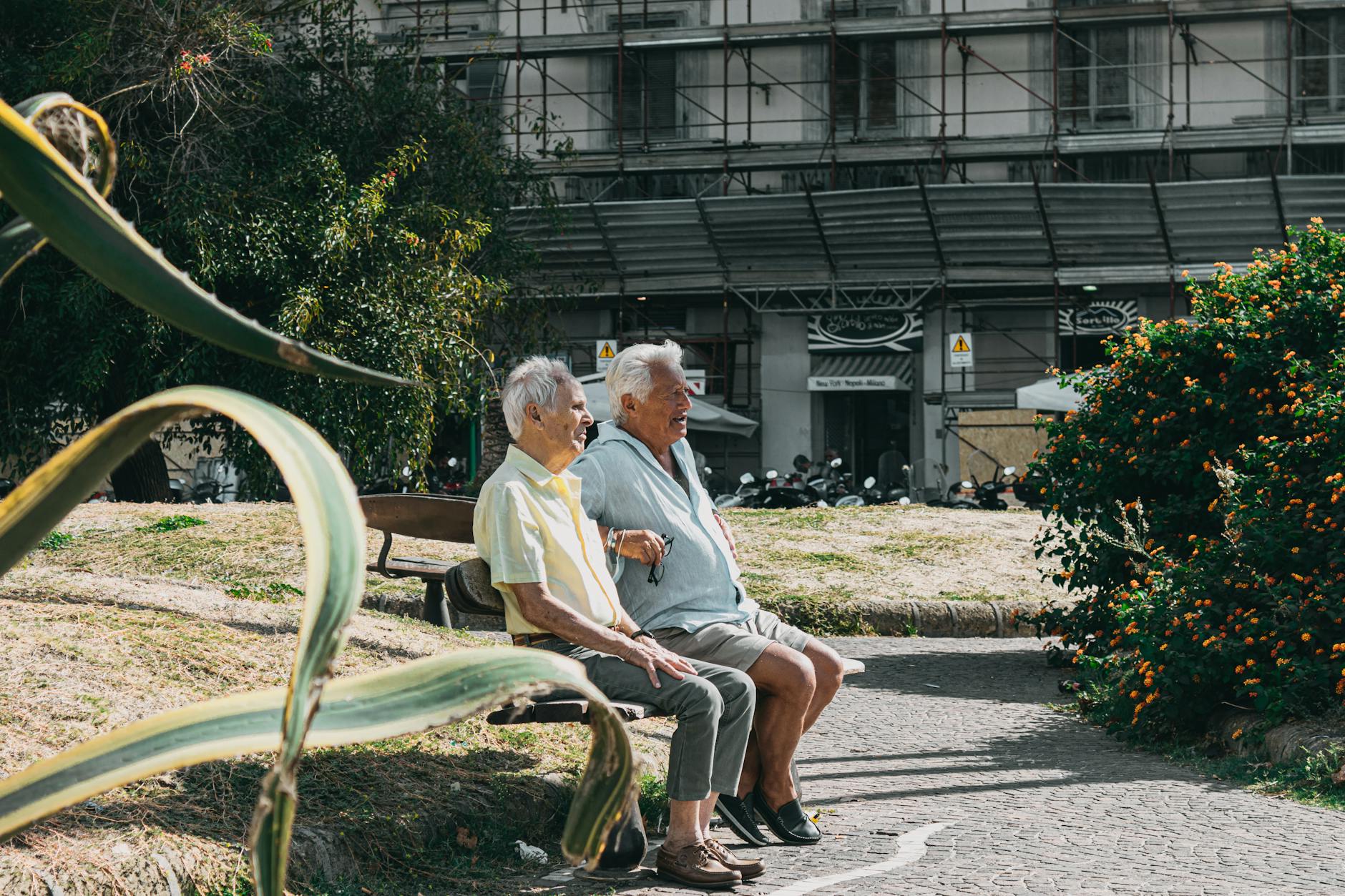 Two older men sitting on a park bench in Naples