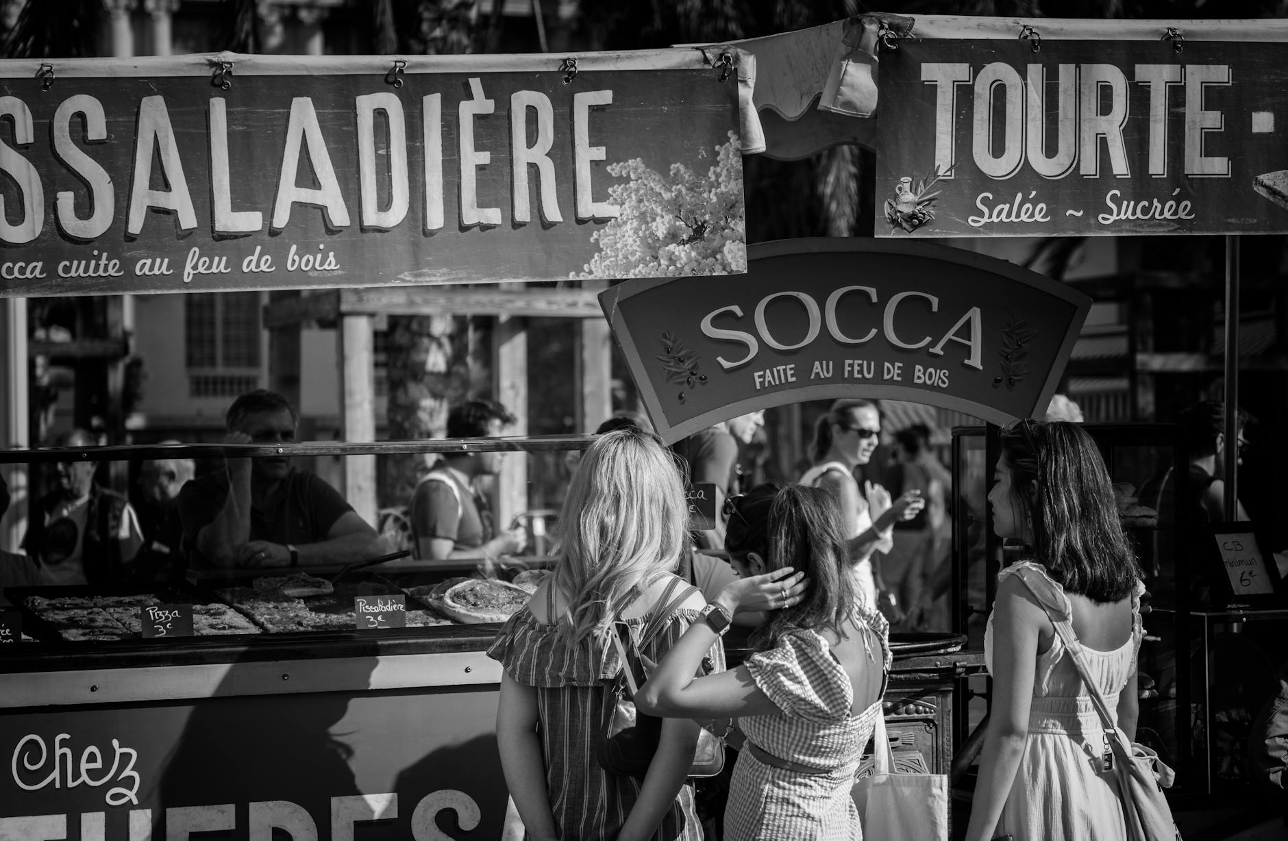 Street market in Nice with people browsing food stalls