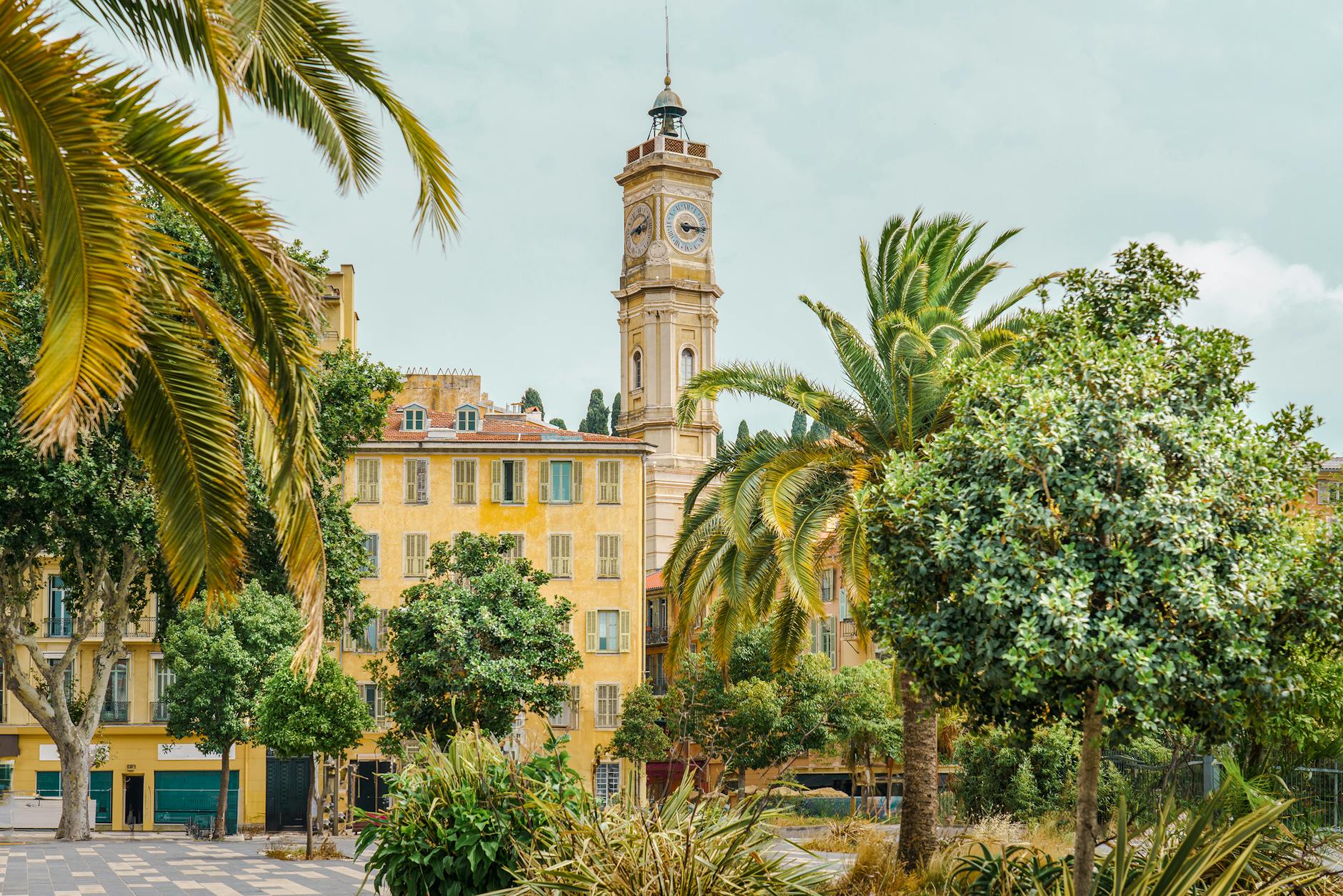 Clock tower and palm trees in sunny Nice