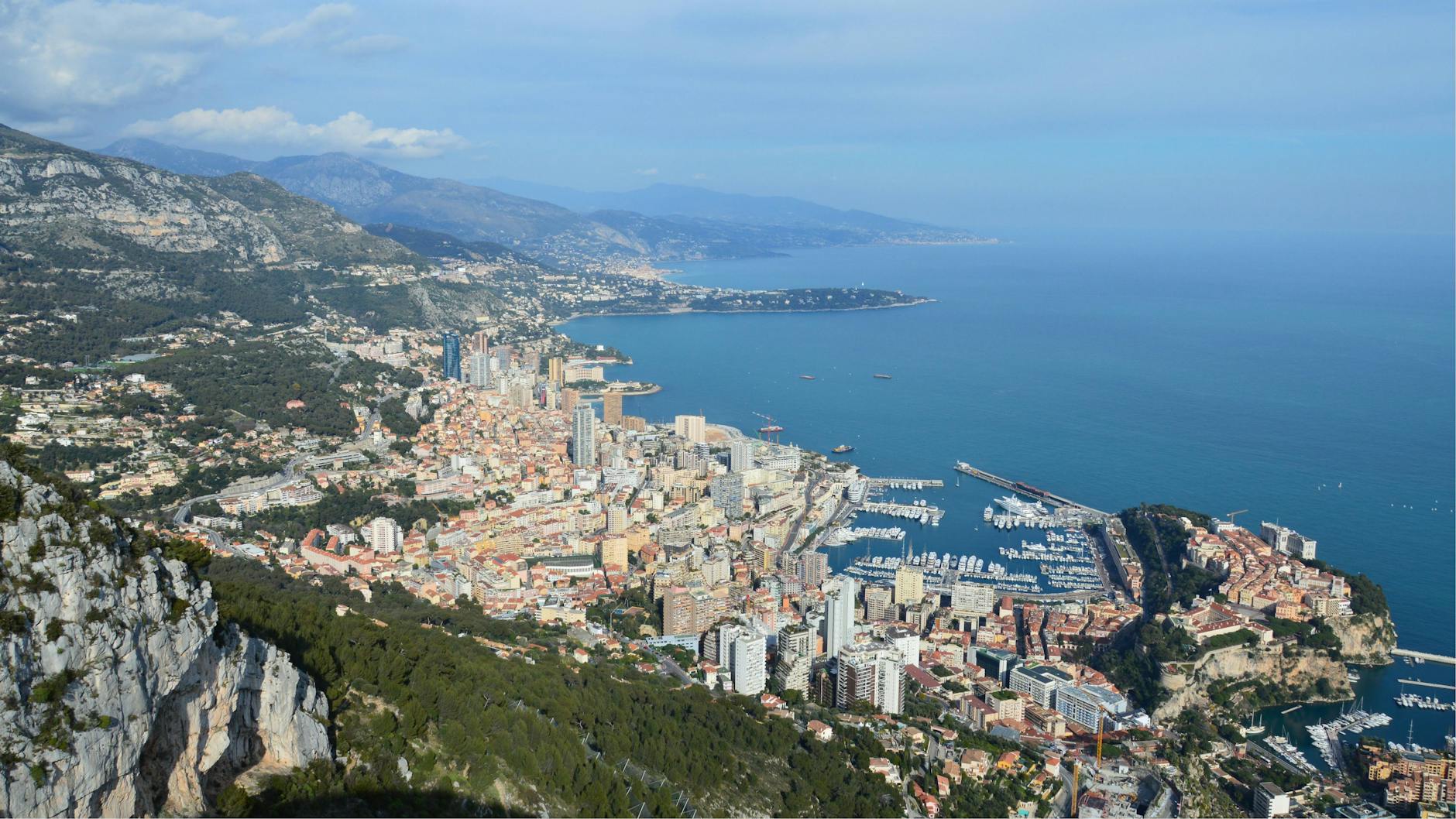 Aerial view of Monaco, mountains, and blue Mediterranean water