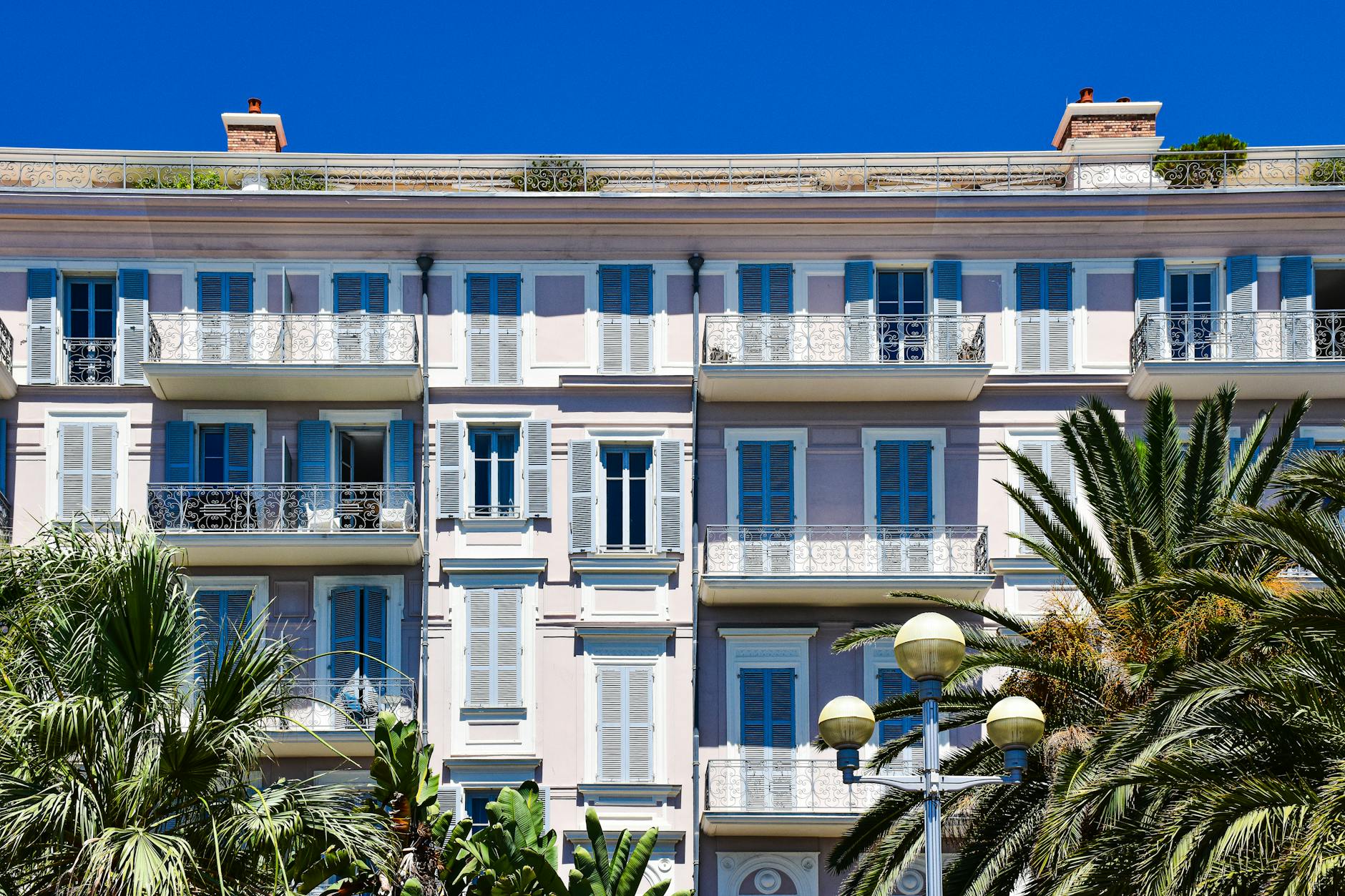 Elegant building facade with balconies and shutters in Nice