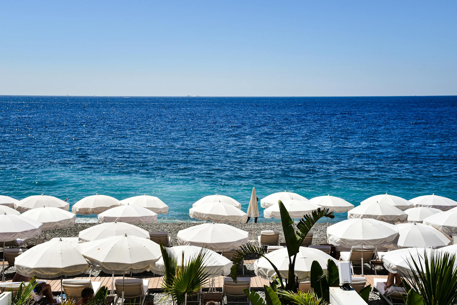 Riviera beach scene with umbrellas and blue sea