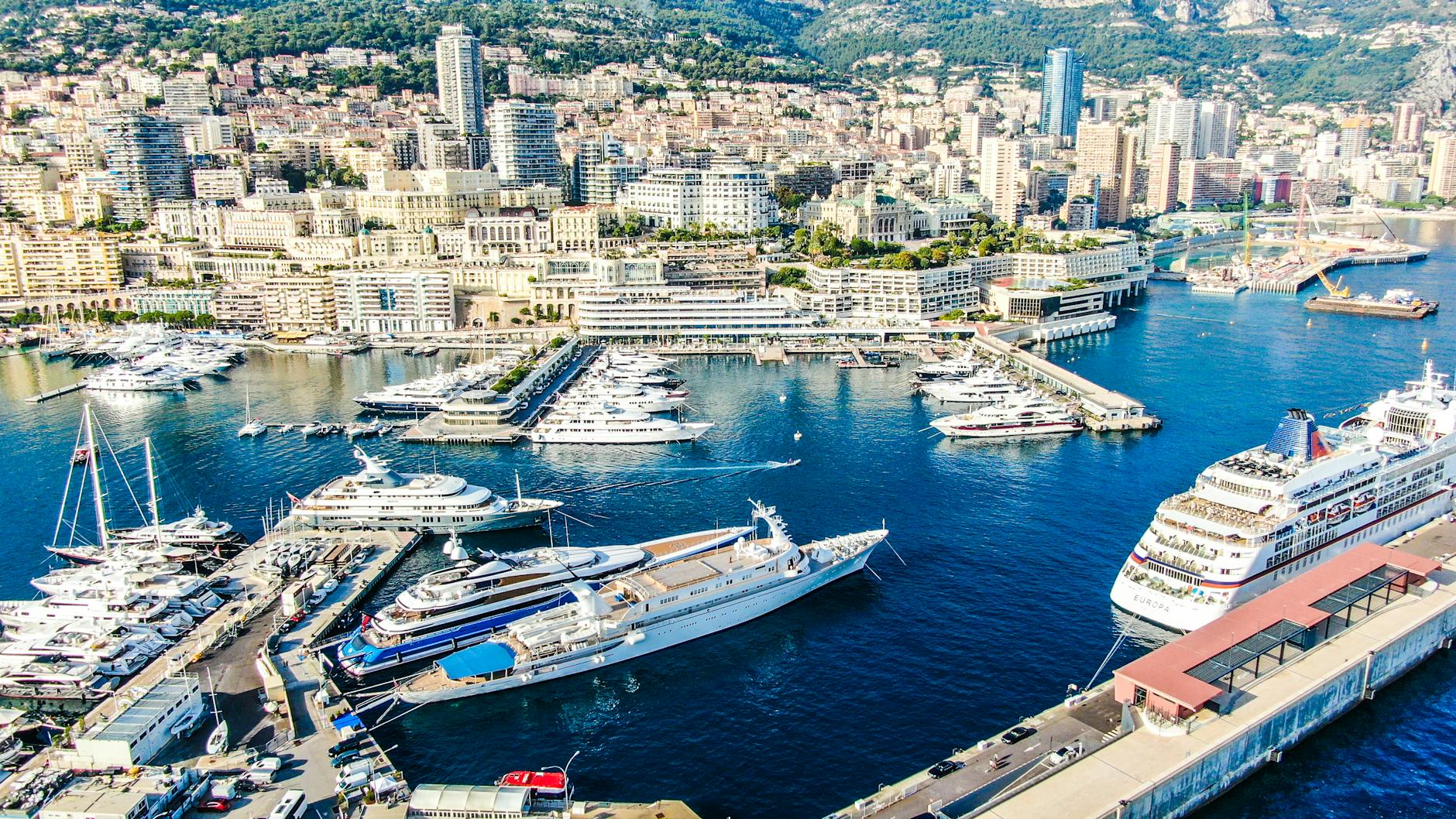 Aerial view of Monaco harbor with yachts and dense cityscape