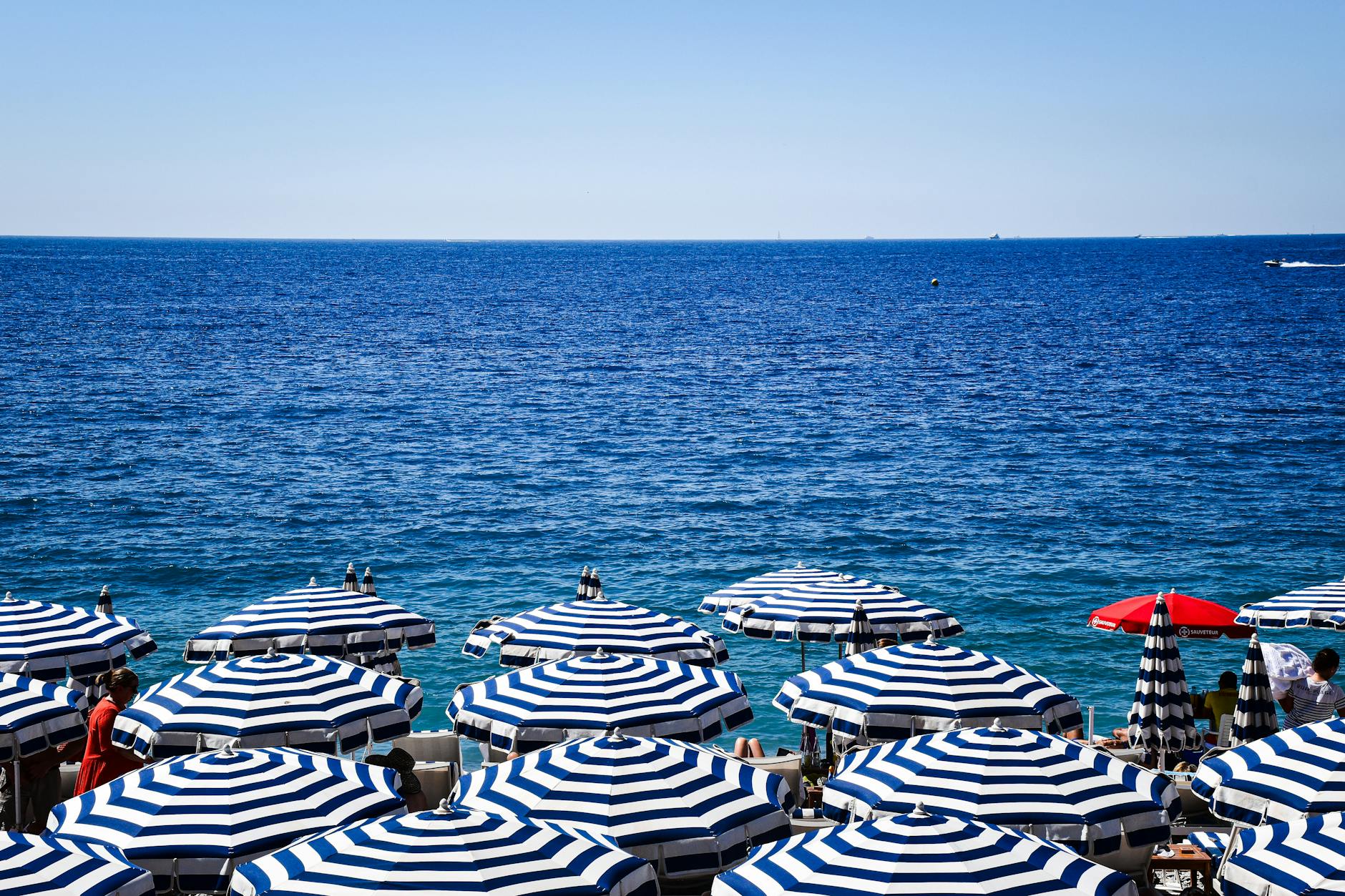 Blue striped umbrellas on a sunny Nice beach