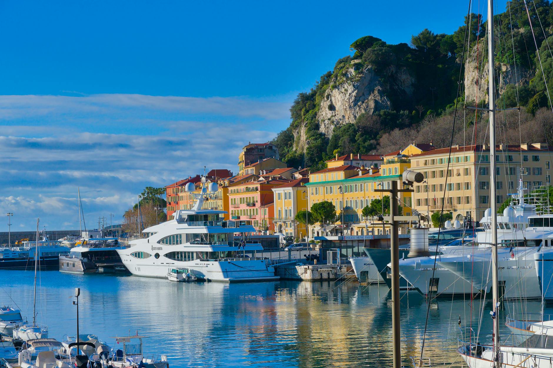 Luxury yachts and colorful buildings in Nice harbor