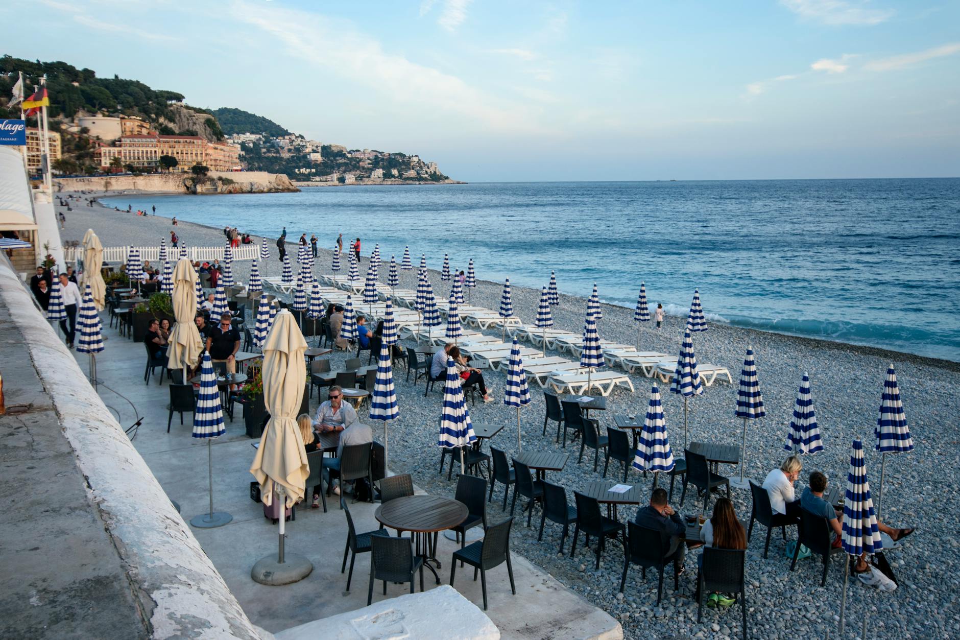 Beachside cafe on the French Riviera with striped umbrellas and sea view