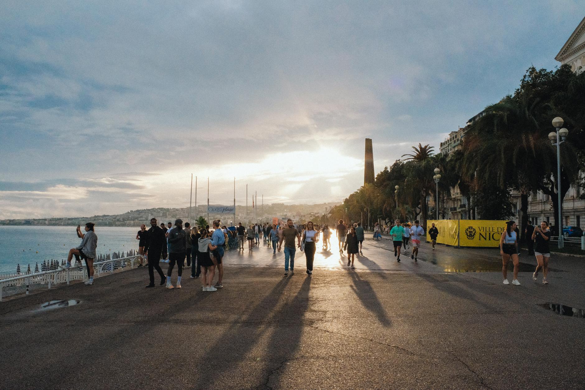 People strolling on the Promenade des Anglais at sunset