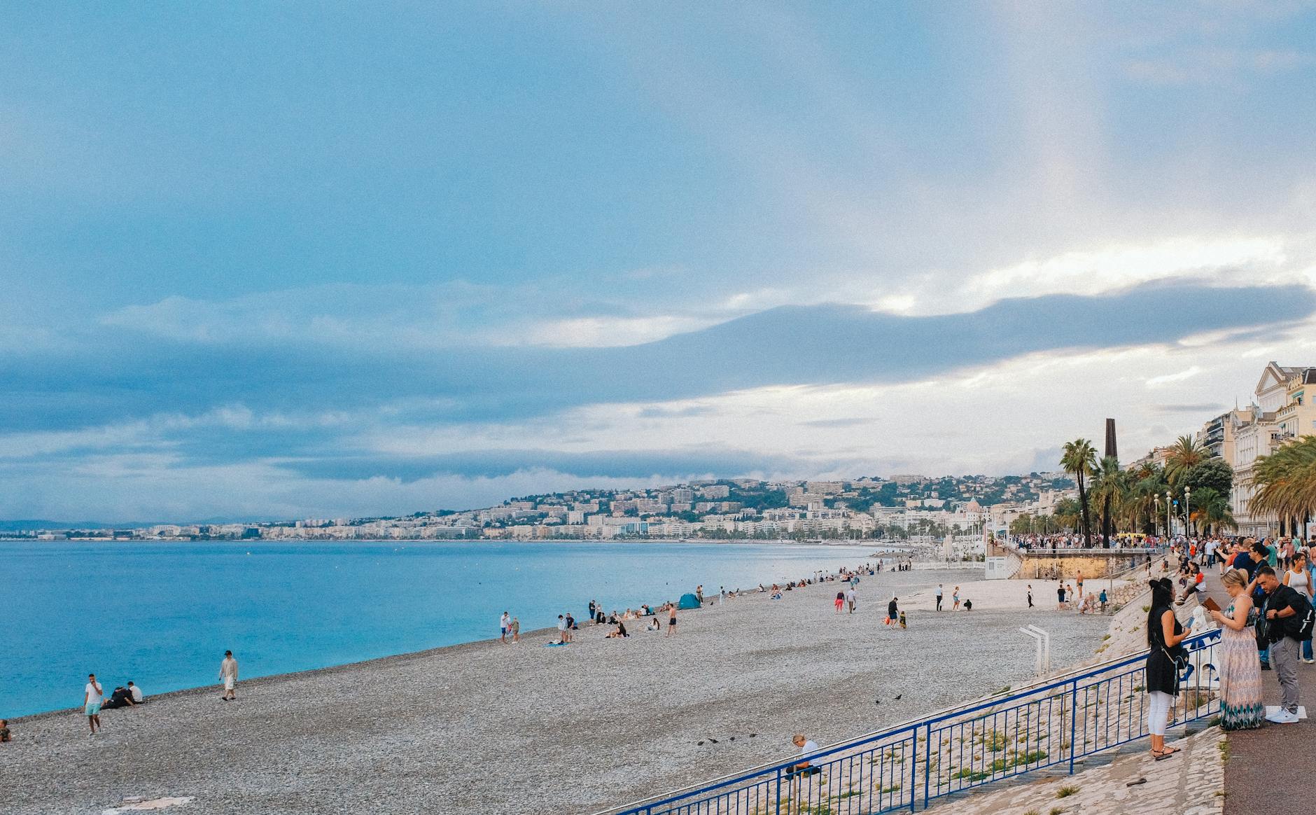 People enjoying the promenade and beach in Nice