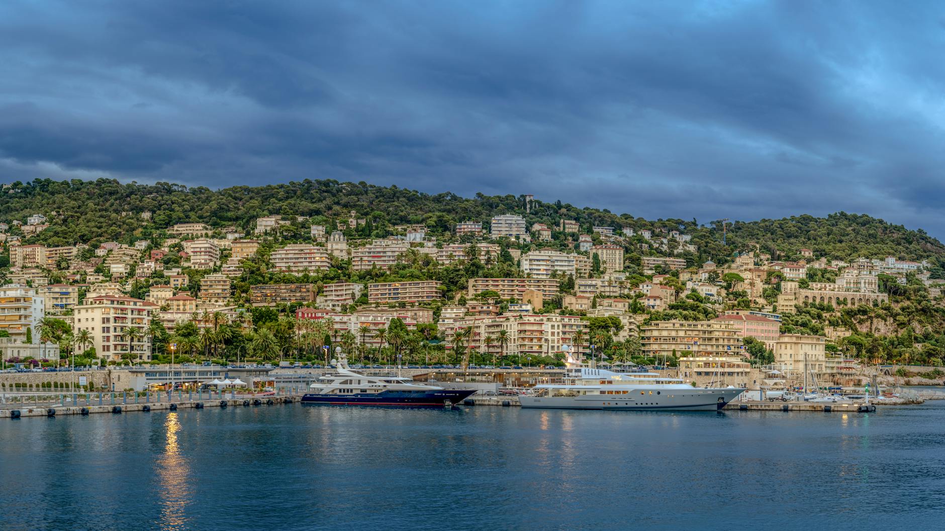 Nice harbor with yachts and mountains behind the city