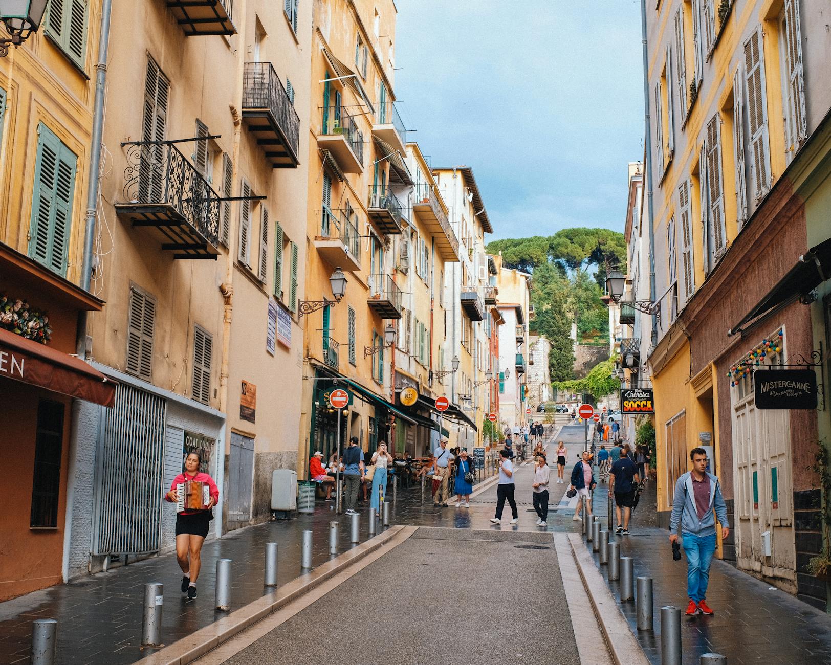 People walking through colorful Old Town Nice