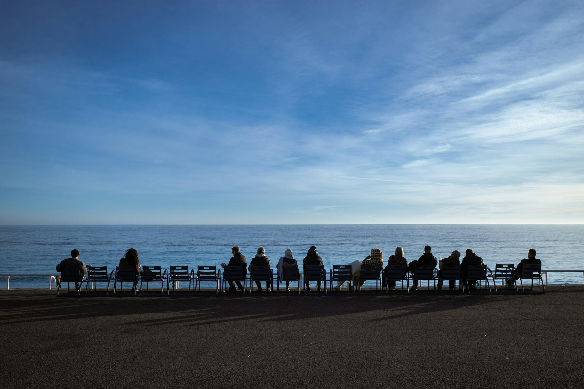 People sitting by the beach in Nice at sunset