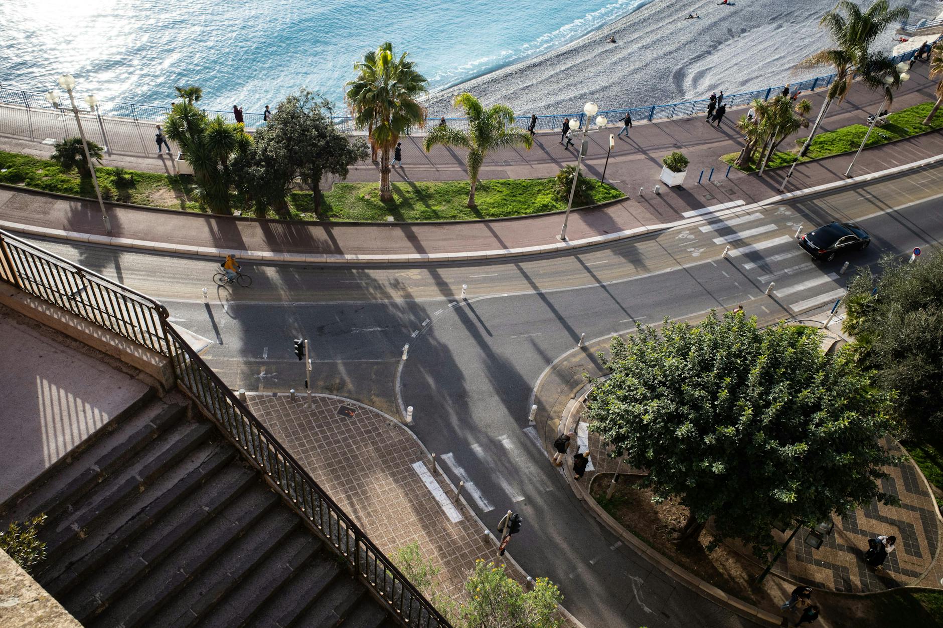 Aerial view of Nice promenade, palm trees, beach, and coastal road
