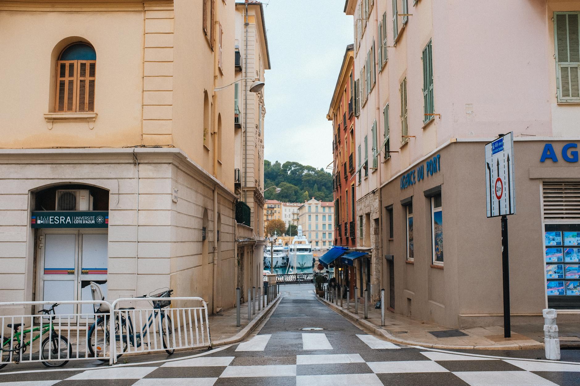 Street view leading toward a lively port with boats
