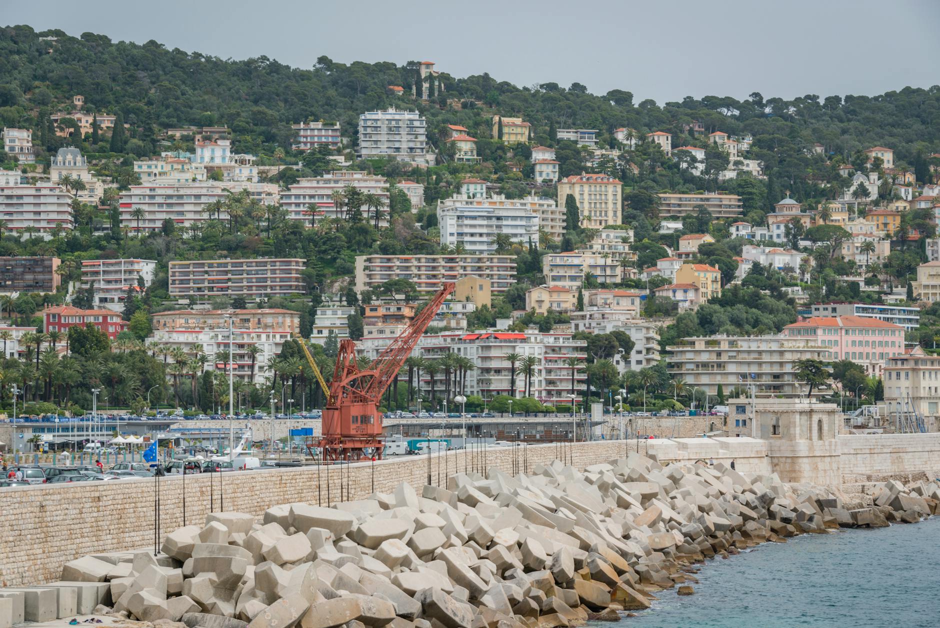 Coastal cityscape with marina, greenery, and classic Riviera architecture