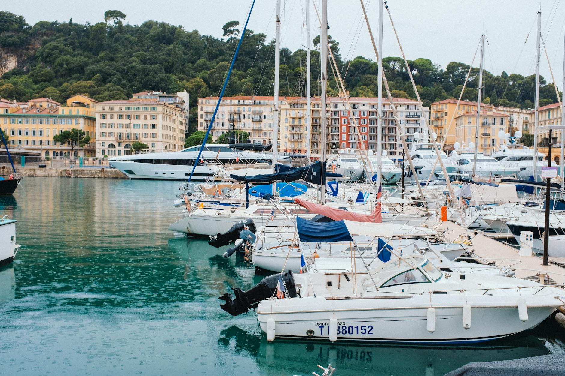 Boats docked at a Mediterranean marina under a cloudy sky