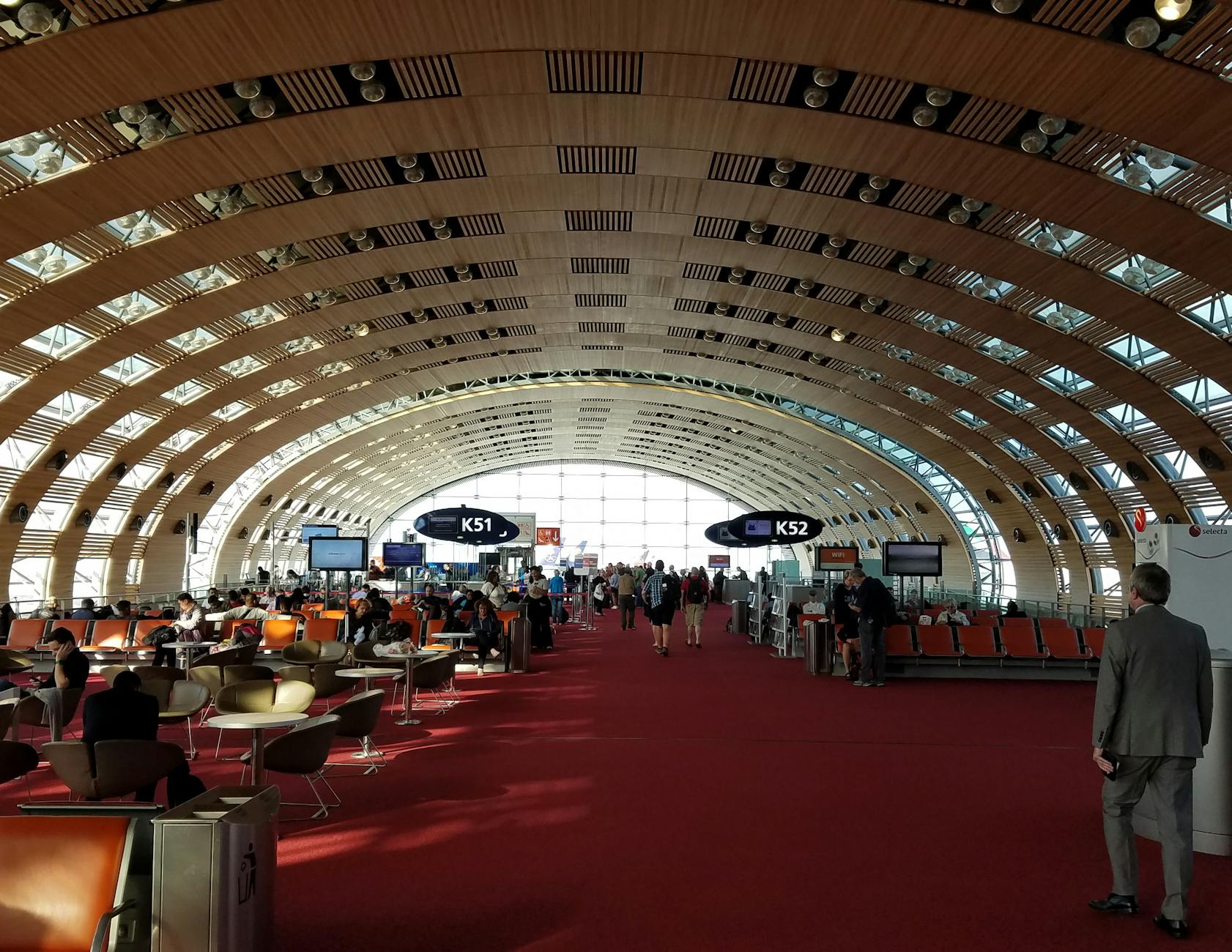Travelers inside a spacious airport terminal