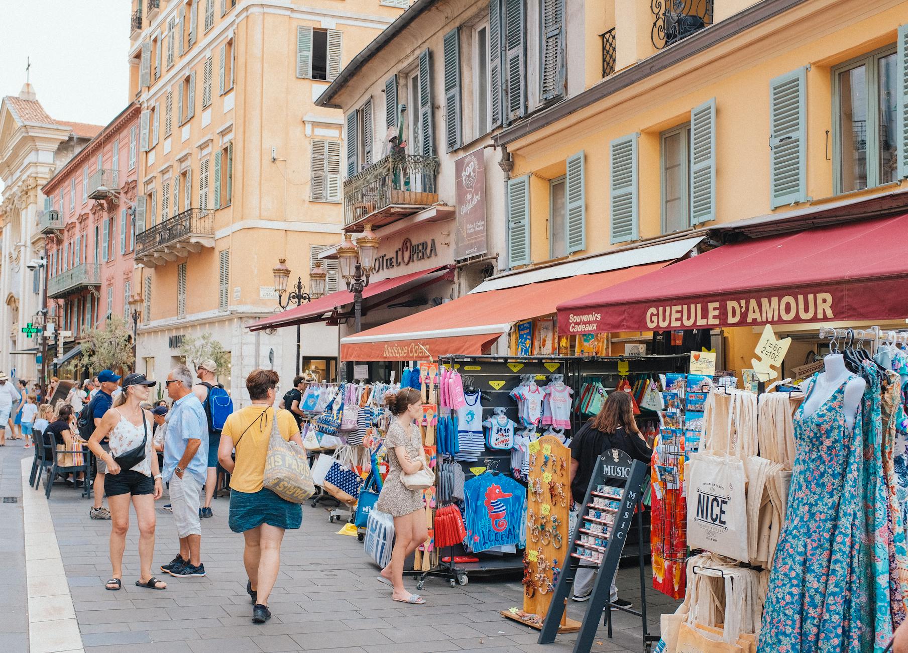 Street market scene in Nice with shoppers and colorful storefronts