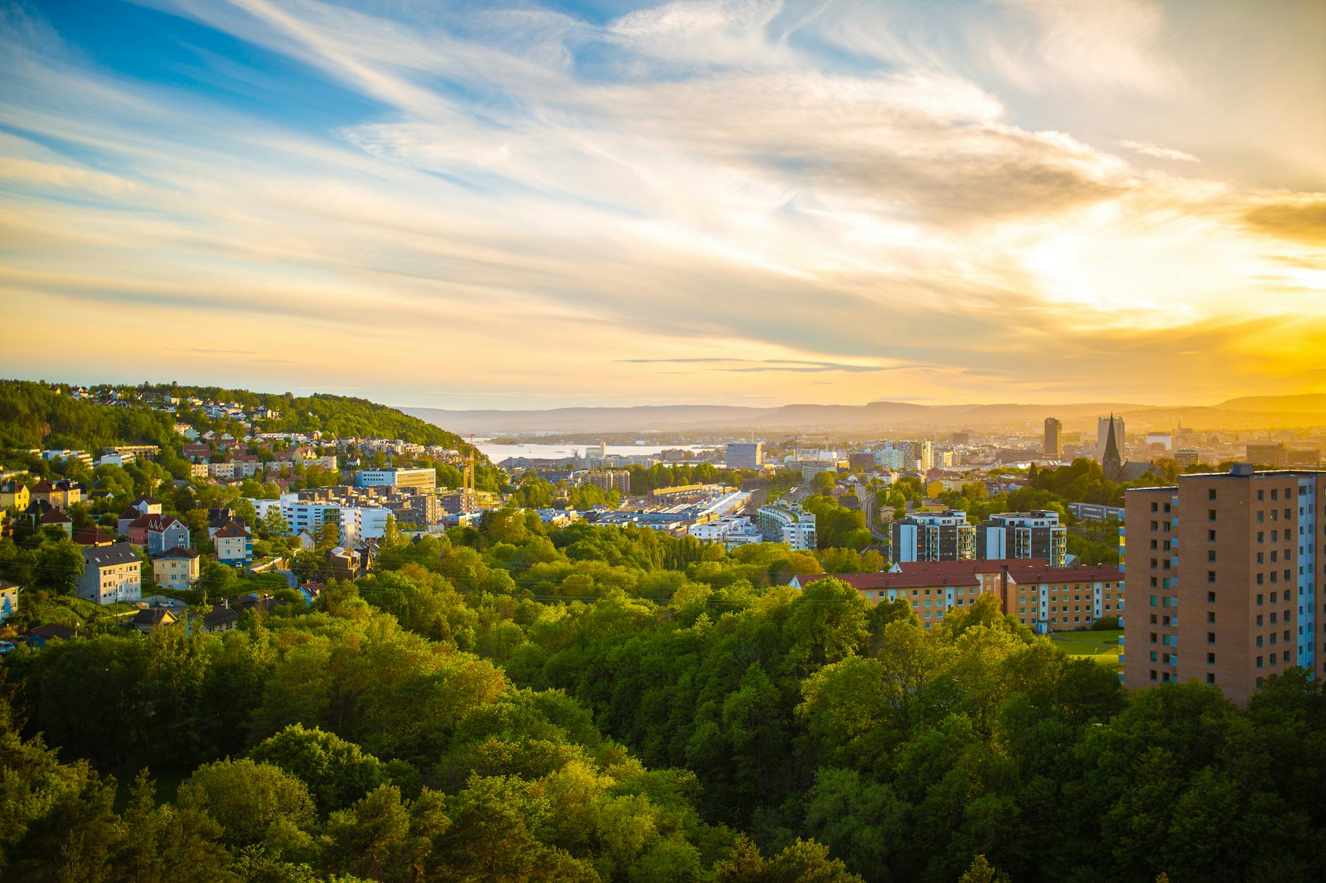 Aerial view of Oslo with greenery and sunset sky