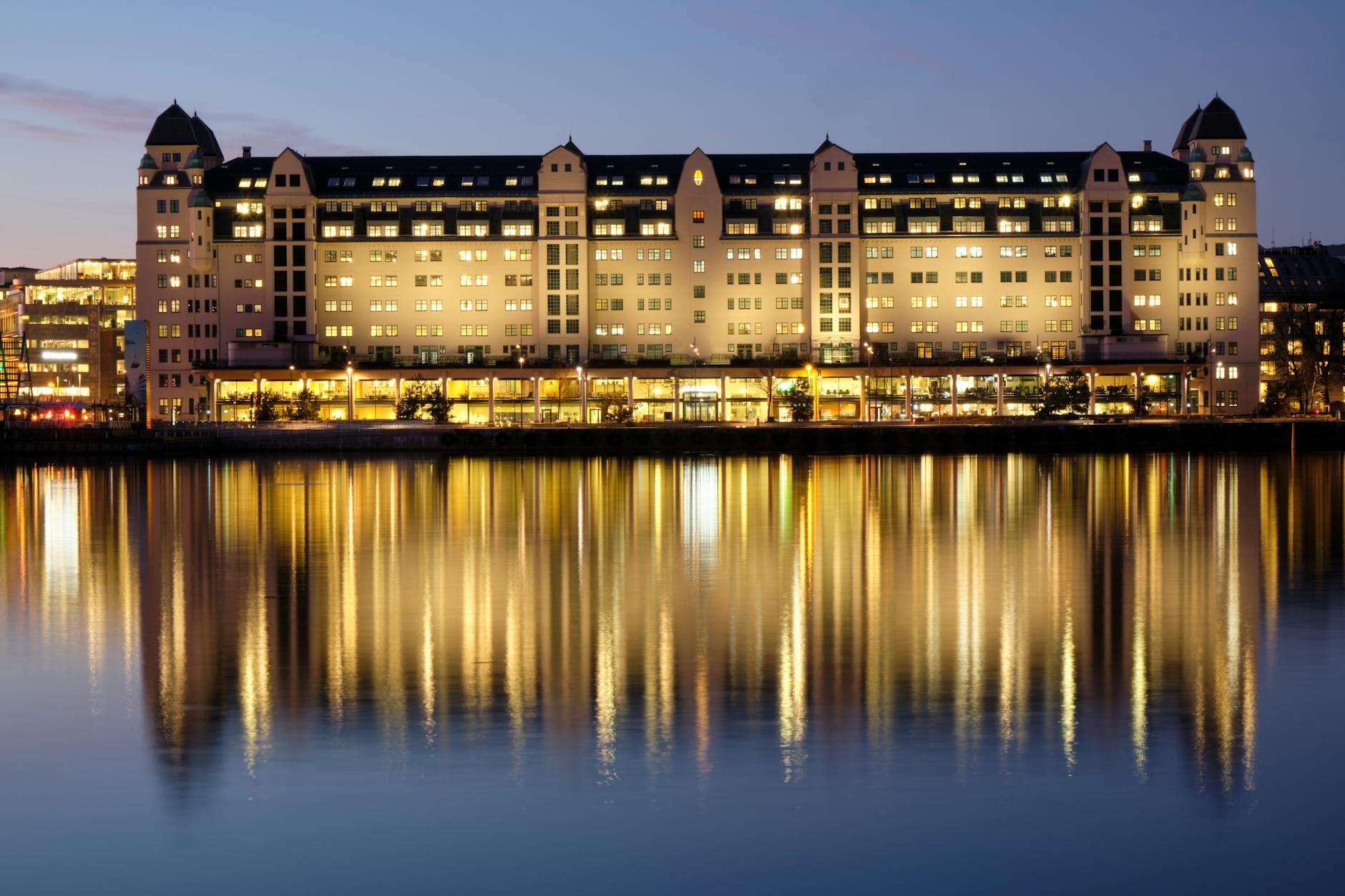 Havnelageret building reflected on Oslo waterfront at twilight