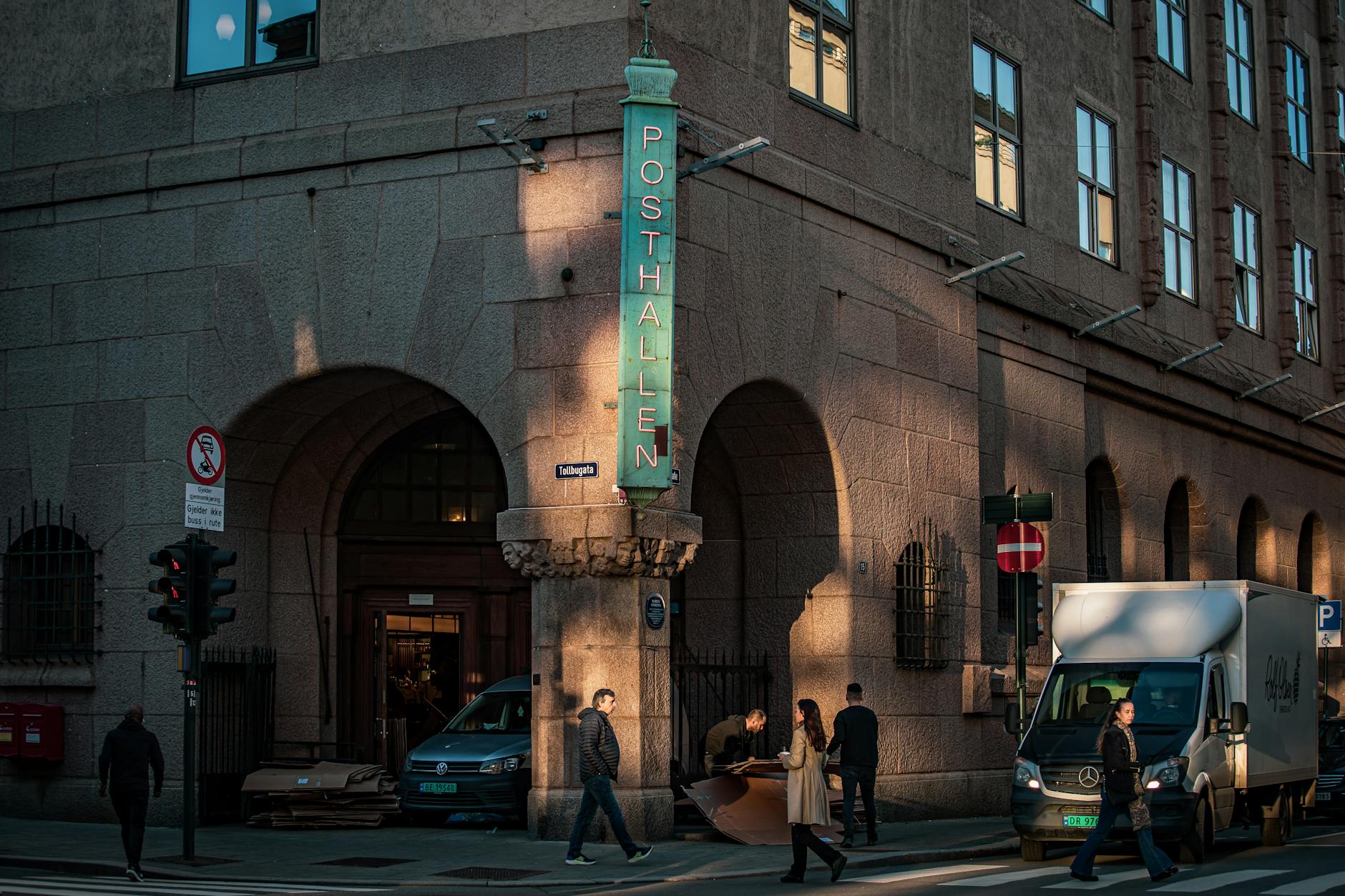 People walking outside Posthallen in Oslo at dusk