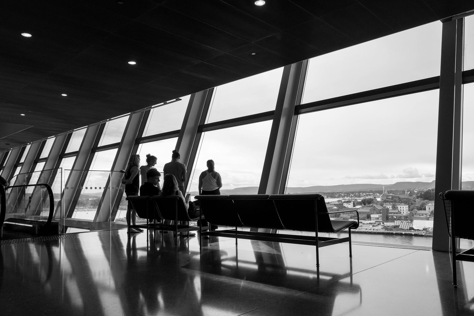People silhouetted against a panoramic window in Oslo
