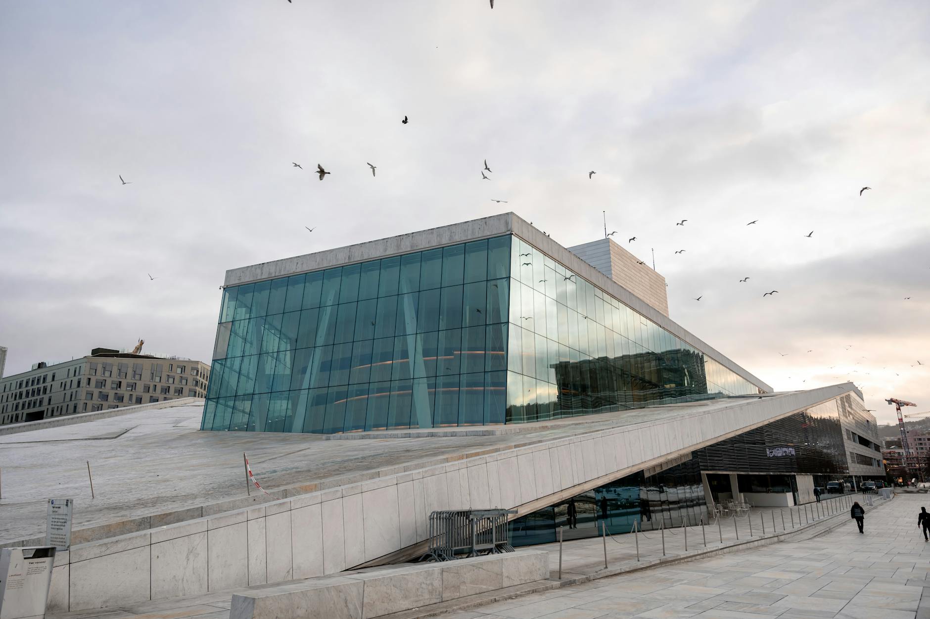 Glass facade of Oslo Opera House reflecting the sky