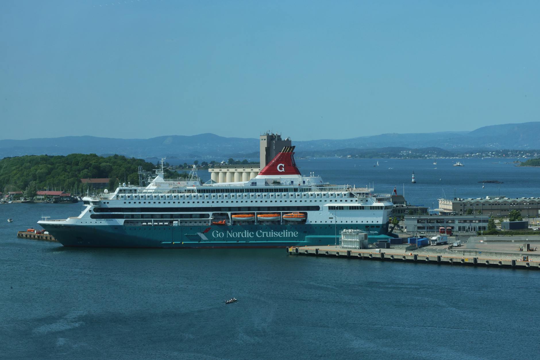 Cruise ship docked at Oslo harbor under a clear blue sky