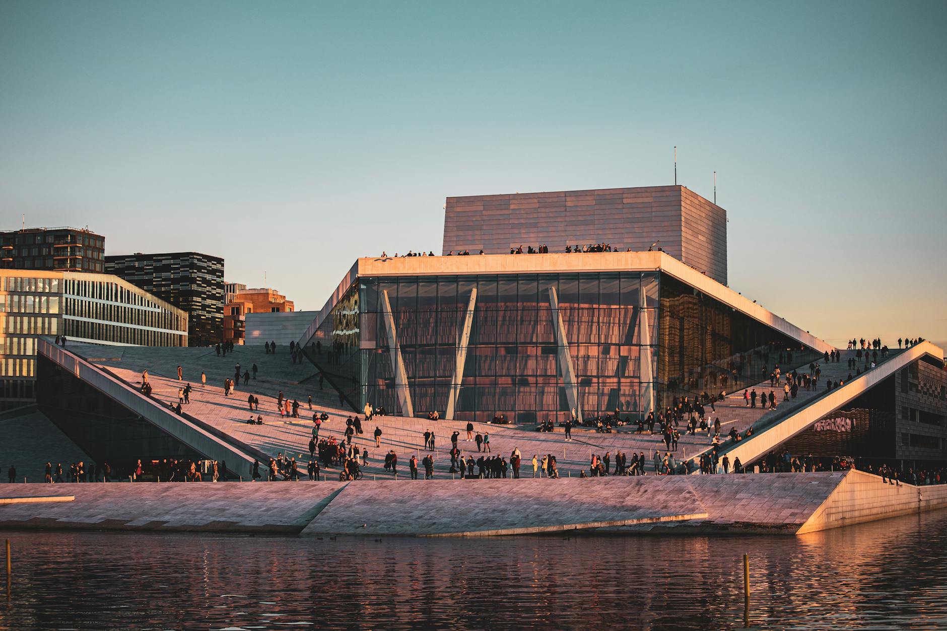 Oslo Opera House waterfront at sunset with people outside