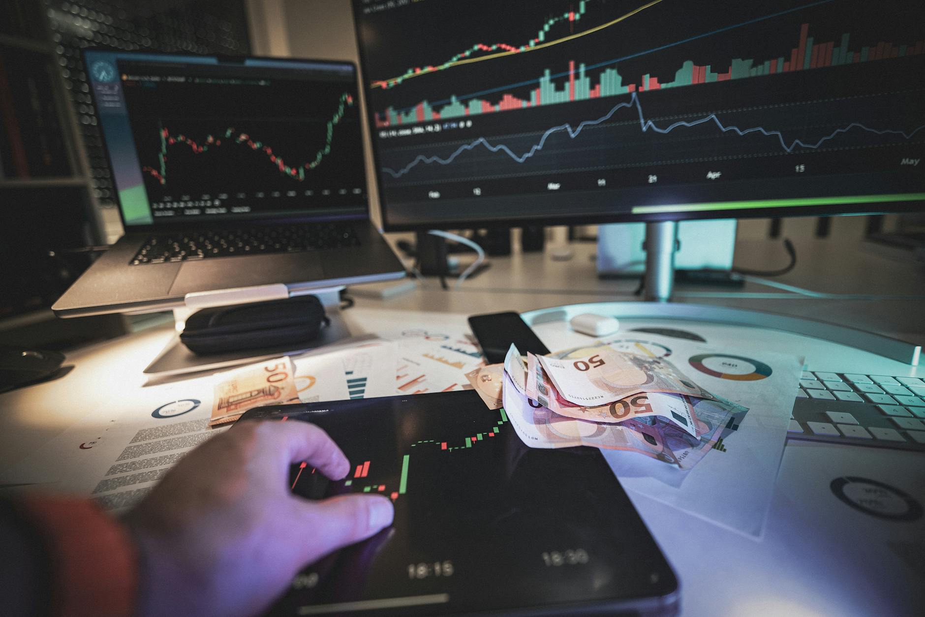Trading desk with market screens and euro notes