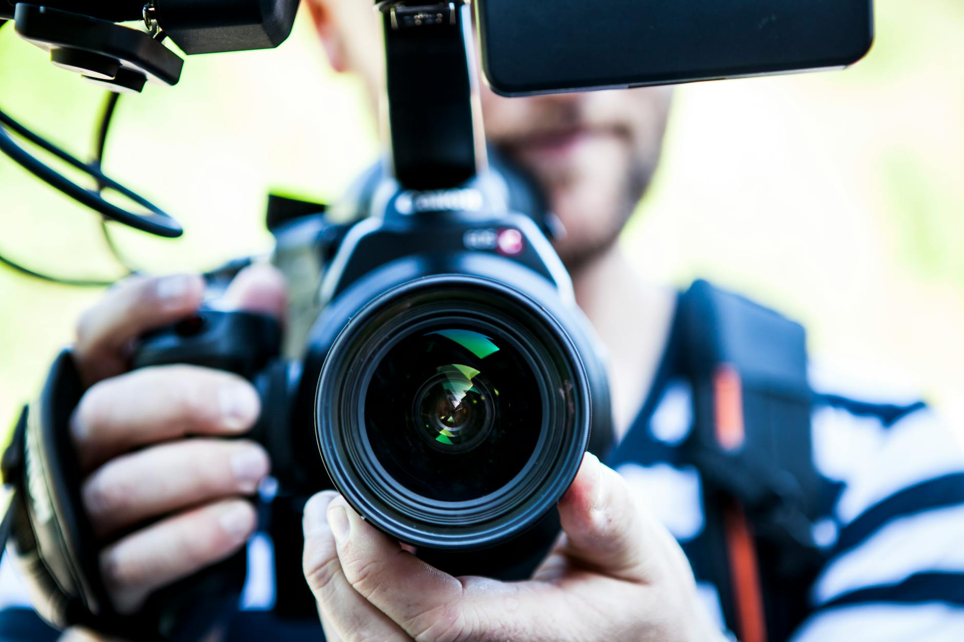 Close-up of a cameraman filming with professional equipment
