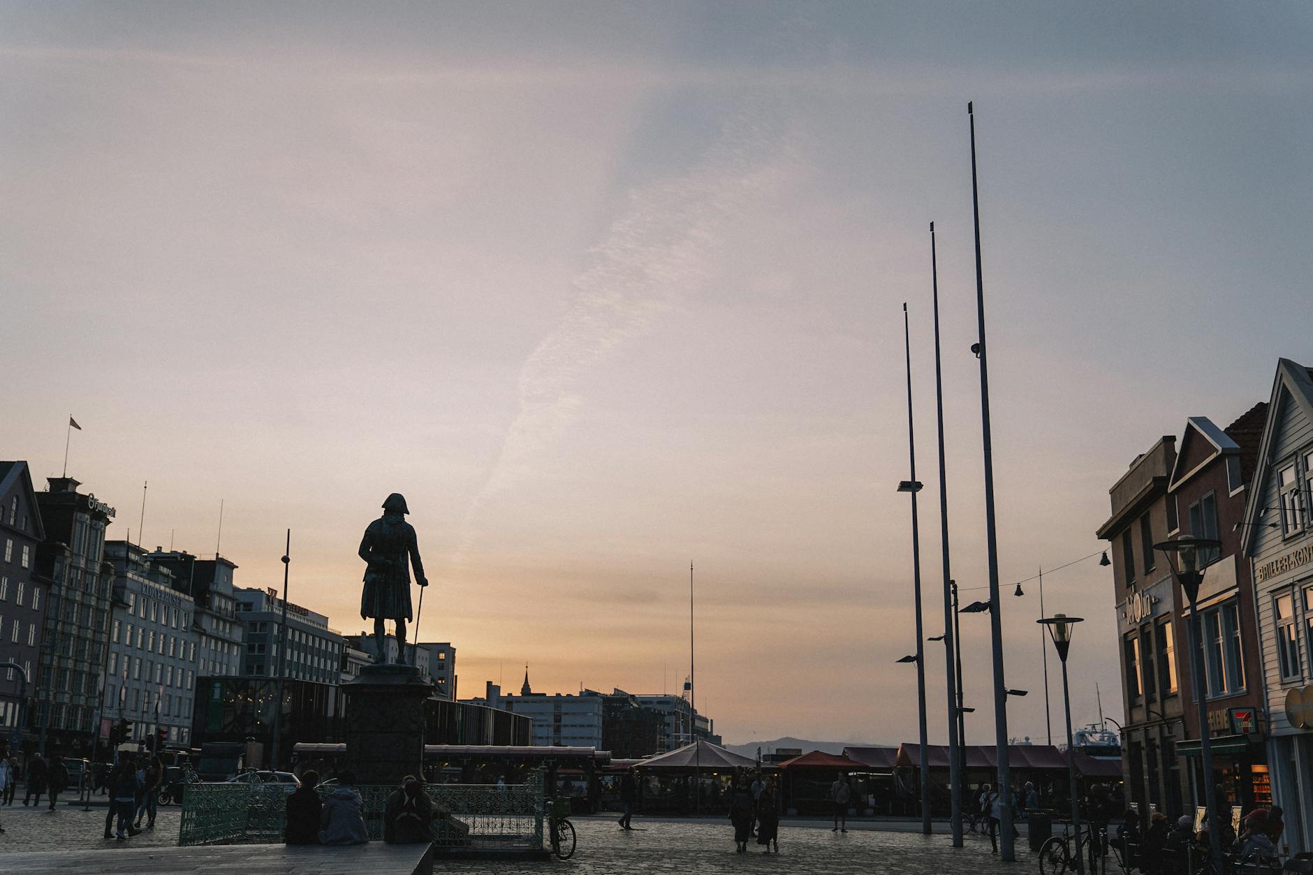 Silhouetted Oslo statue and city buildings at sunset