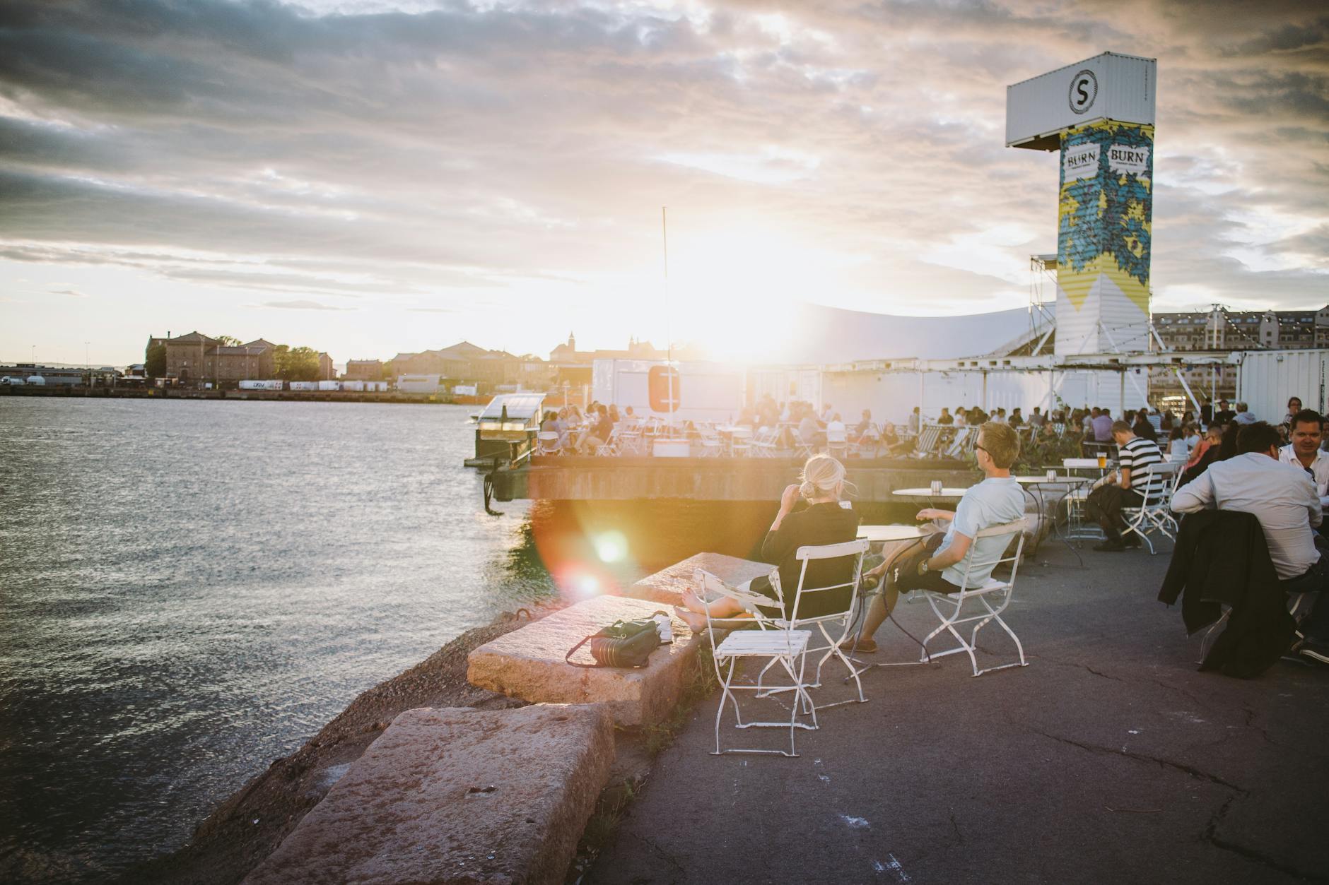 People sitting by the Oslo seaside at sunset