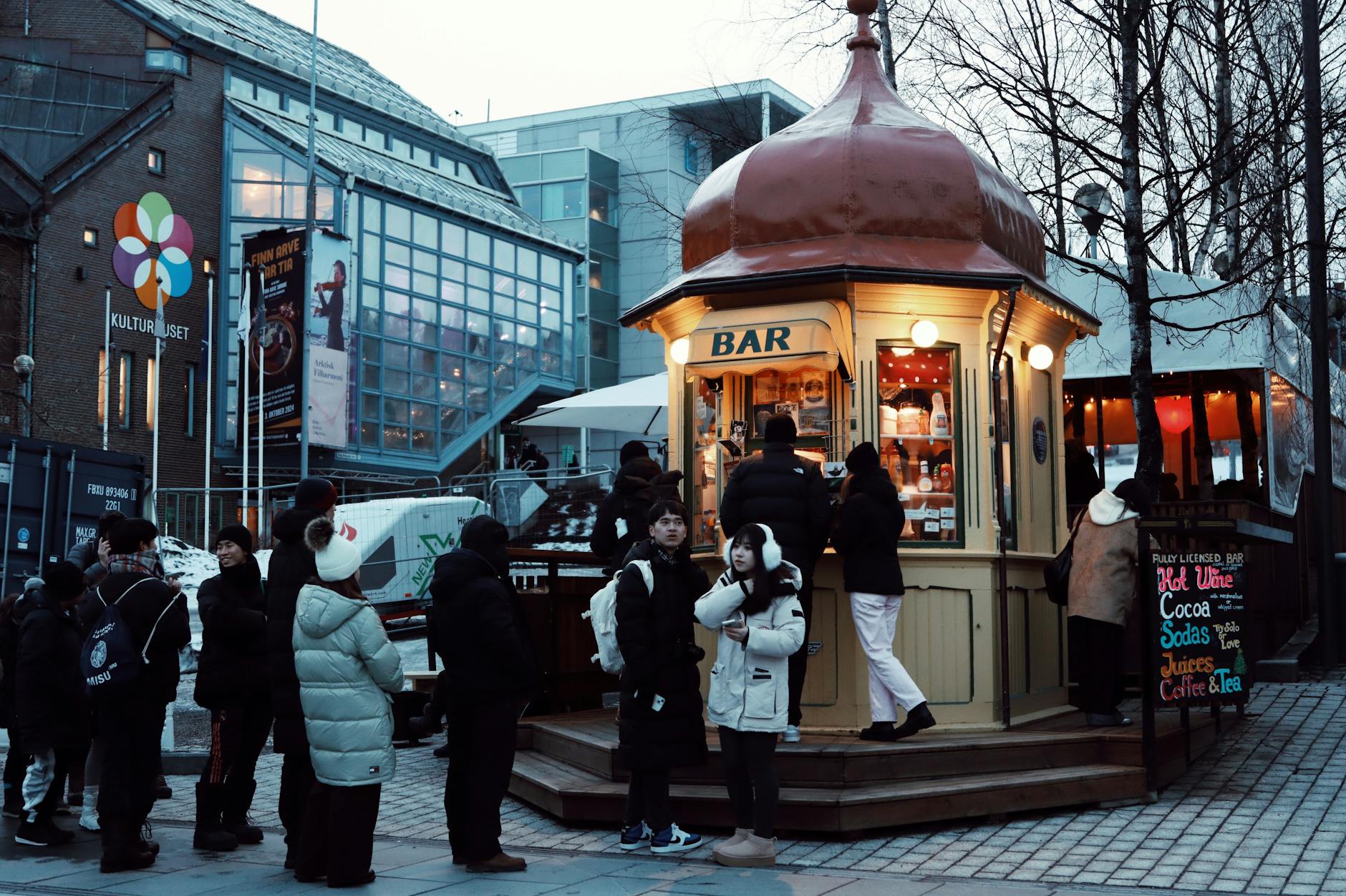 People queueing at a cozy outdoor bar in winter