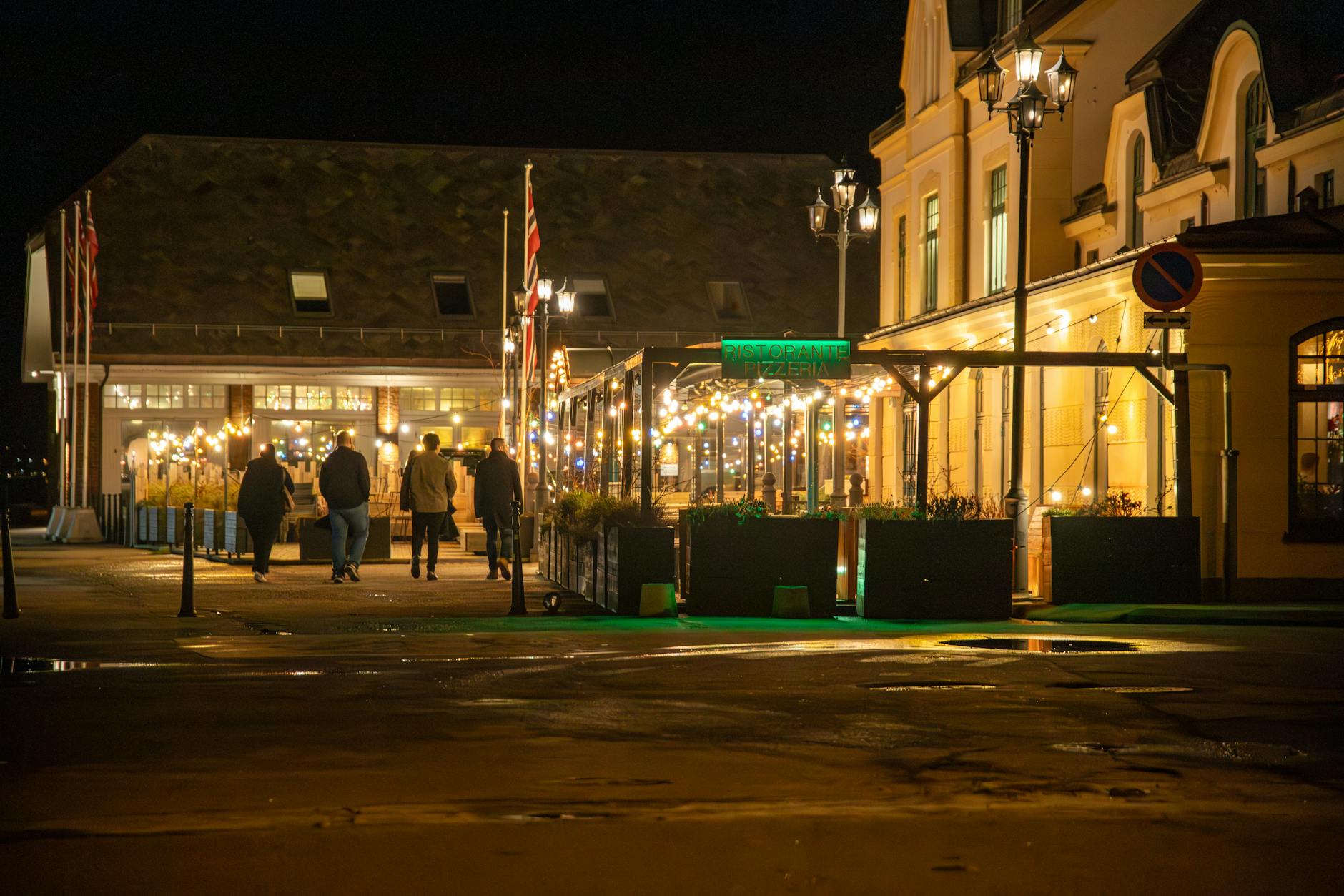 Norwegian downtown street with illuminated restaurant at night