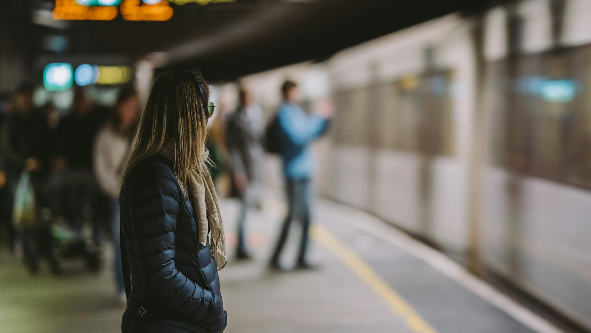 Woman waiting on an Oslo subway platform as a train arrives