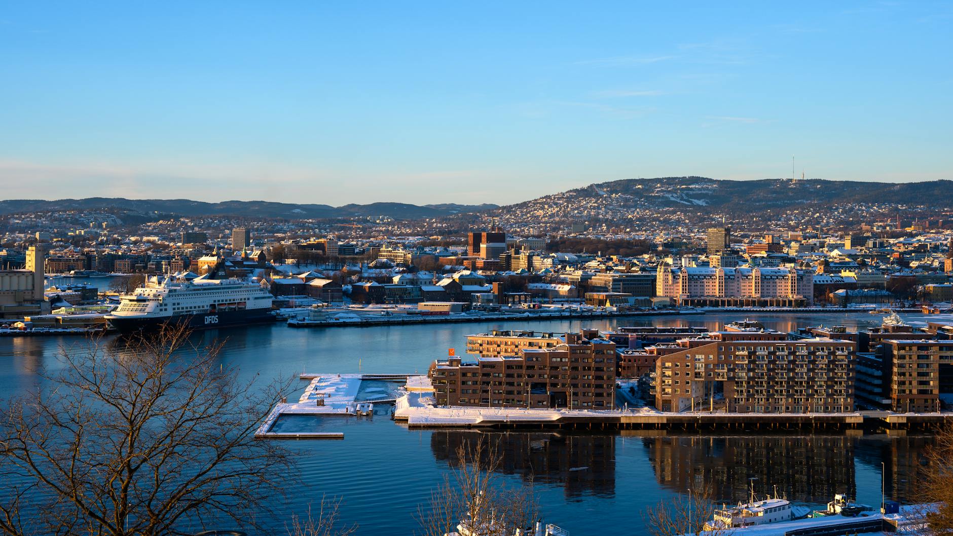 Snowy Oslo cityscape with harbor and rooftops