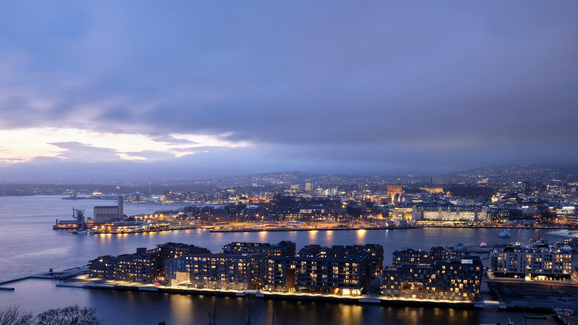 Oslo skyline at dusk with city lights reflected on the water